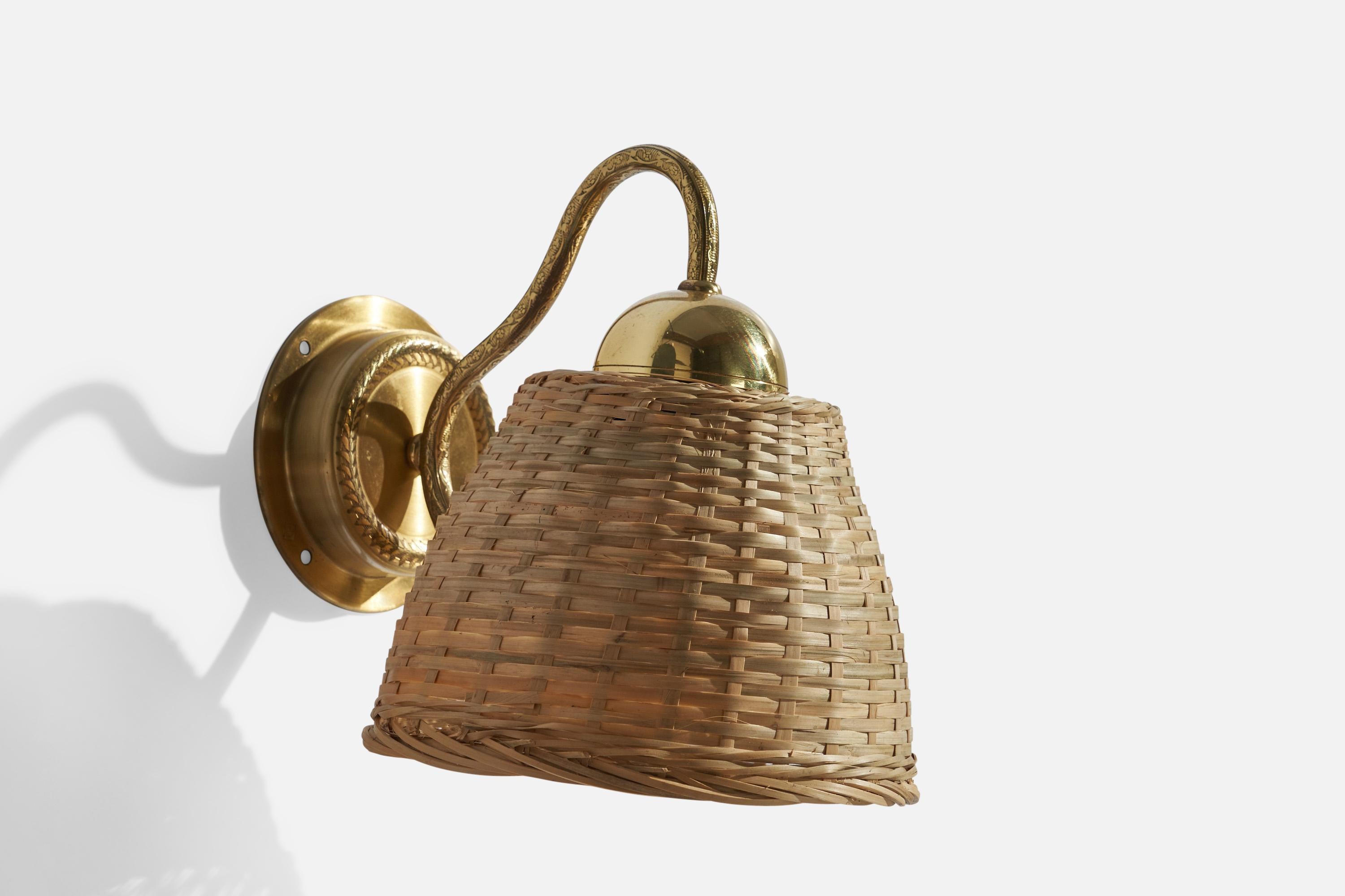 A brass and rattan wall light, designed and produced by EWÅ Värnamo, Sweden, c. 1970s.

Overall Dimensions (inches): 8.5” H x 7” W x 9.5”  D
Back Plate Dimensions (inches): 4.25” H x 4.25” W x 1.0” D
Bulb Specifications: E-26 Bulb
Number of Sockets: