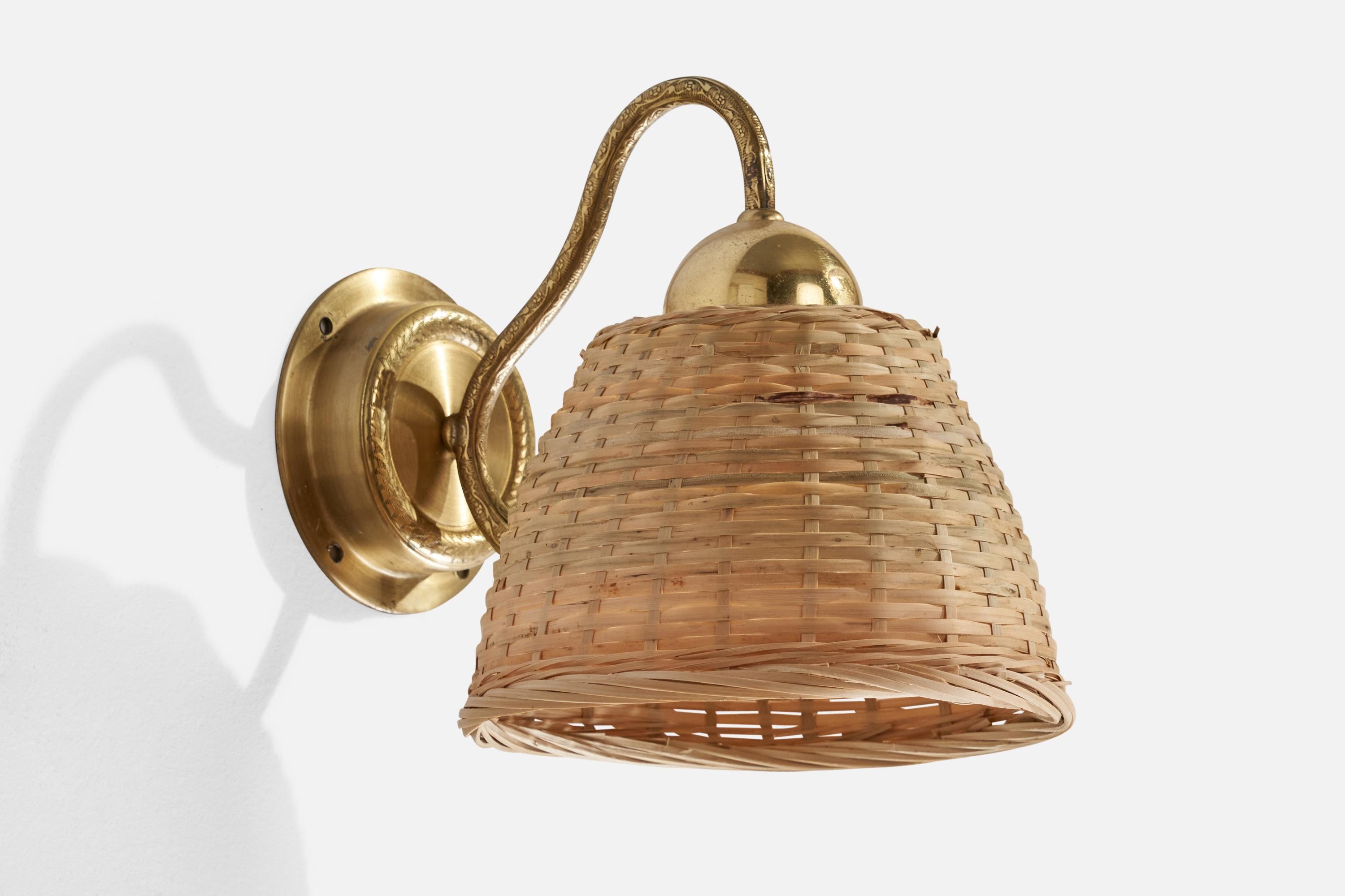 A brass and rattan wall light produced by EWÅ Värnamo, Sweden, 1970s.

Assorted rattan lampshade.
Overall Dimensions (inches): 8.25” H x 8.25” W x 7.25” D
Back Plate Dimensions (inches): 4.19” H x 1.1” D
Bulb Specifications: E-26 Bulb
Number of