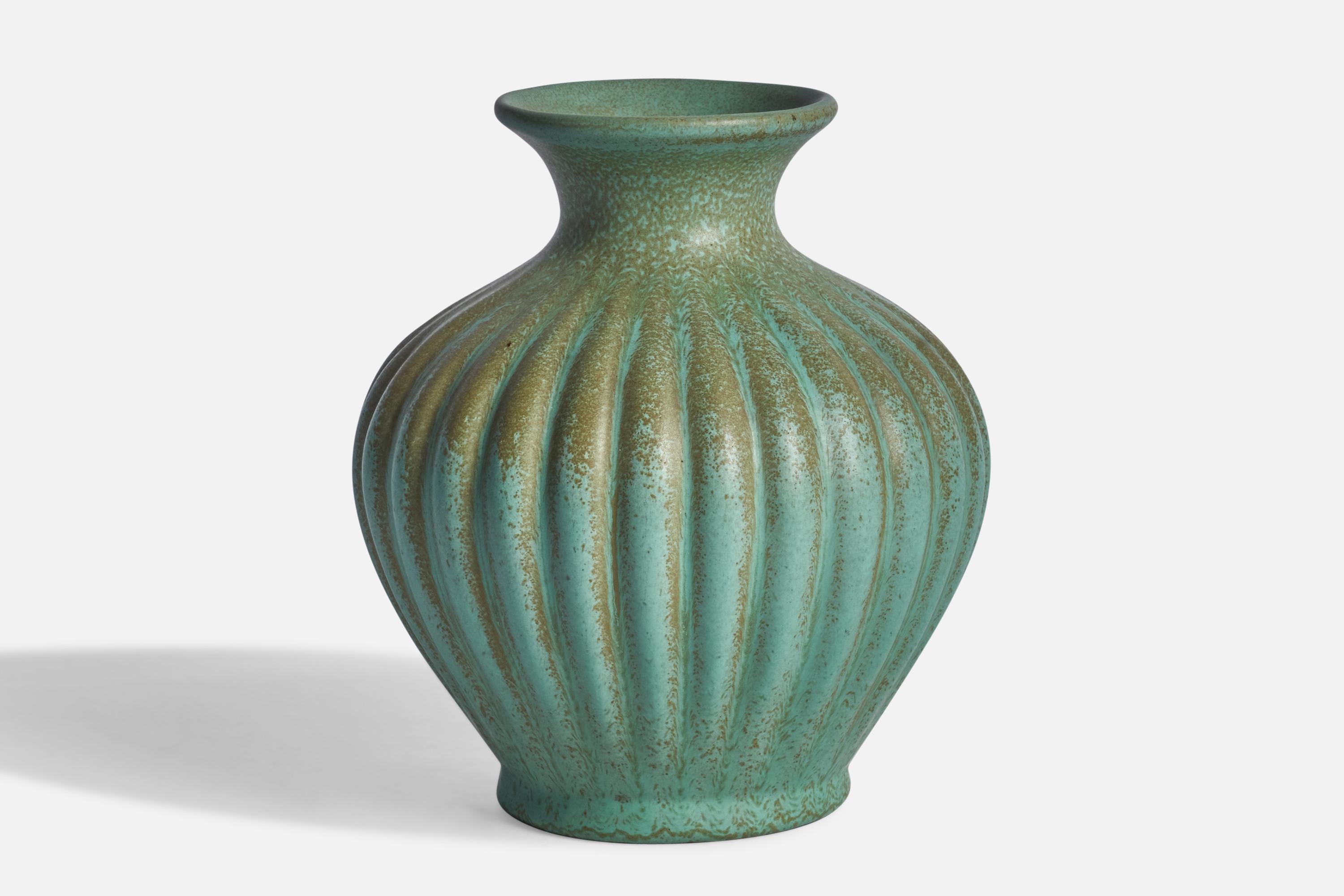 A green-glazed fluted earthenware vase designed by Ewald Dahlskog and produced by Bo Fajans, Sweden, c. 1930s.
“SMARAGD” stamp on bottom