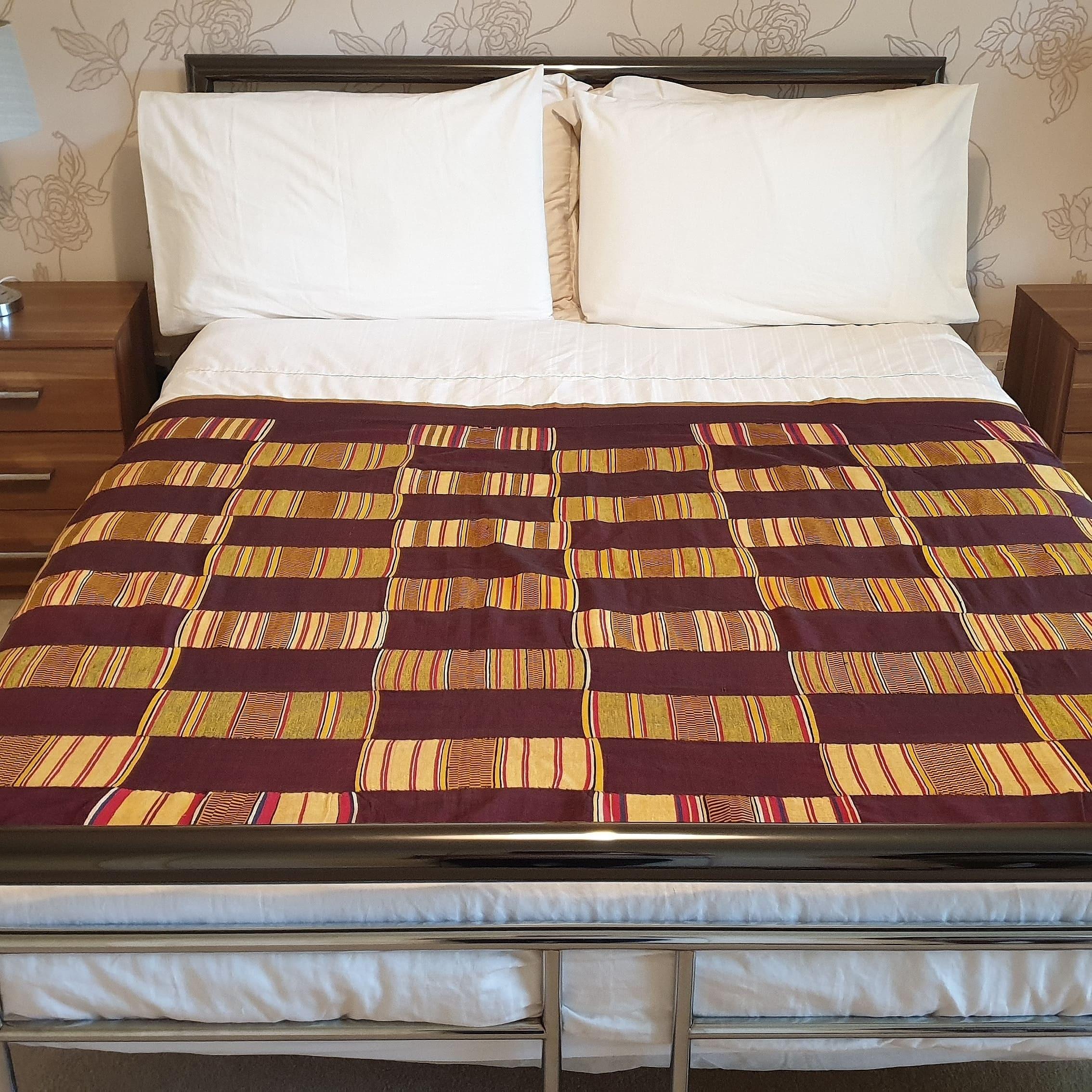 Il s'agit d'un très beau textile Ewe Kente de la région de Volta au Ghana. Tissé à partir de coton filé à la main et de teintures naturelles. Il s'agit d'une pièce royale, comme l'indique le tissage en blocs d'or sur un fond bordeaux rare. 
Cette