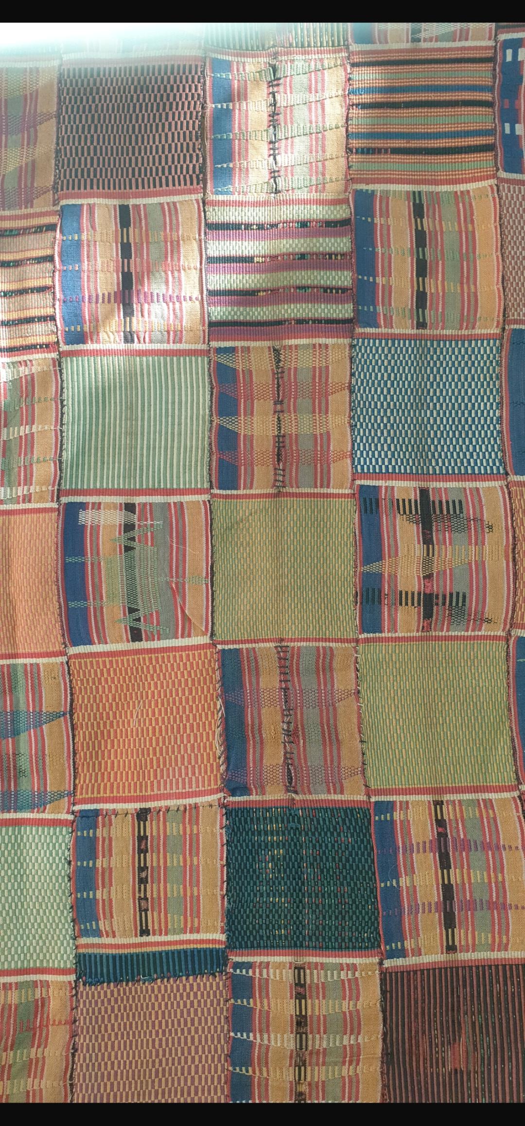 Si tratta di un rarissimo esempio di tessuto Ewe Kente proveniente dalla regione del Volta, in Ghana. Tessuto in cotone filato a mano con tinture naturali nelle classiche tonalità autunnali della pecora. Questo pezzo sarebbe stato tessuto per un