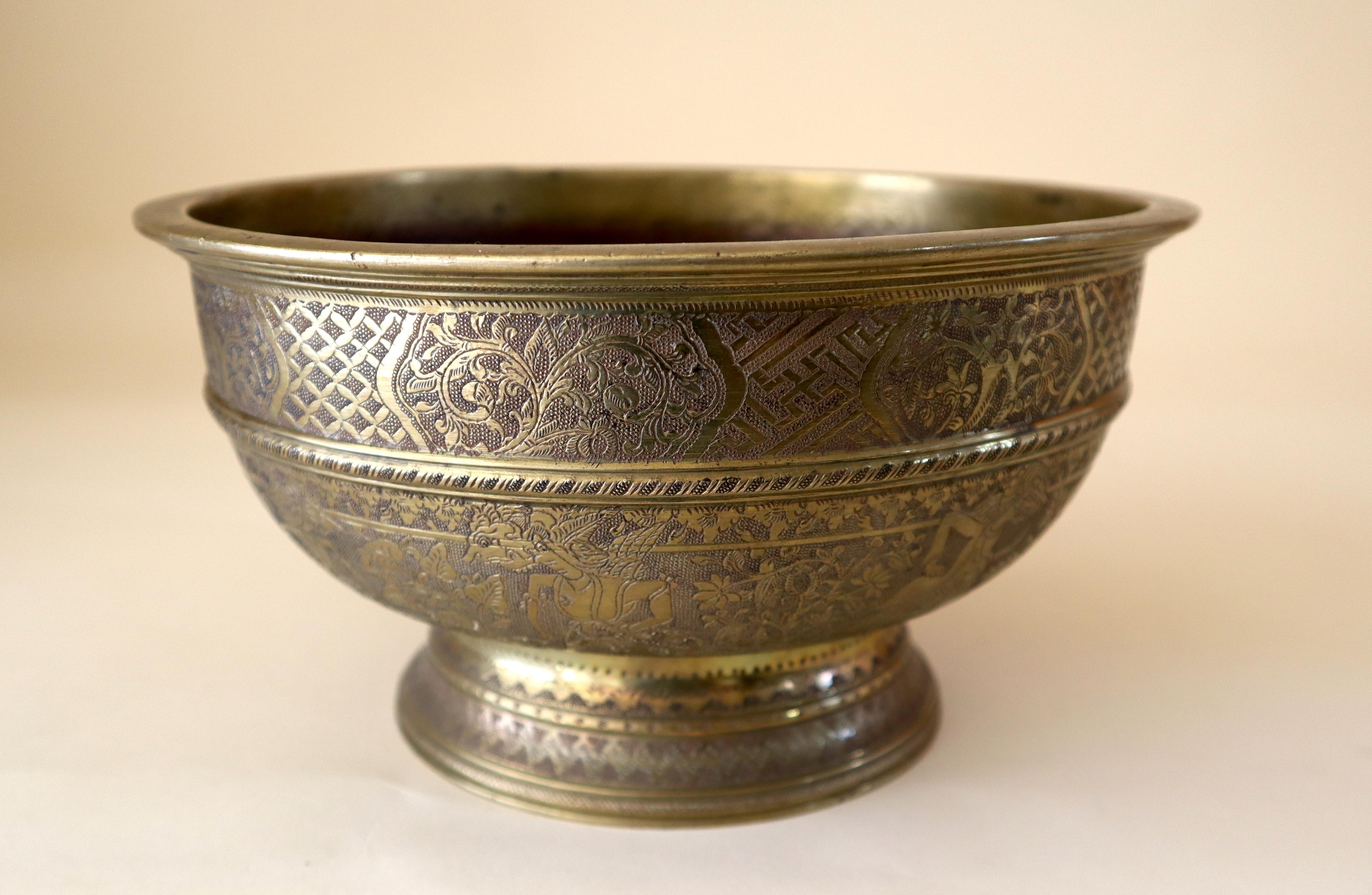 Large heavy bronze or brass bowl, Java, Indonesia, early 20th century. The entire exterior chased with an upper band of floral motifs and a lower band of traditional Indonesian mythological characters most often encountered as shadow puppets (called
