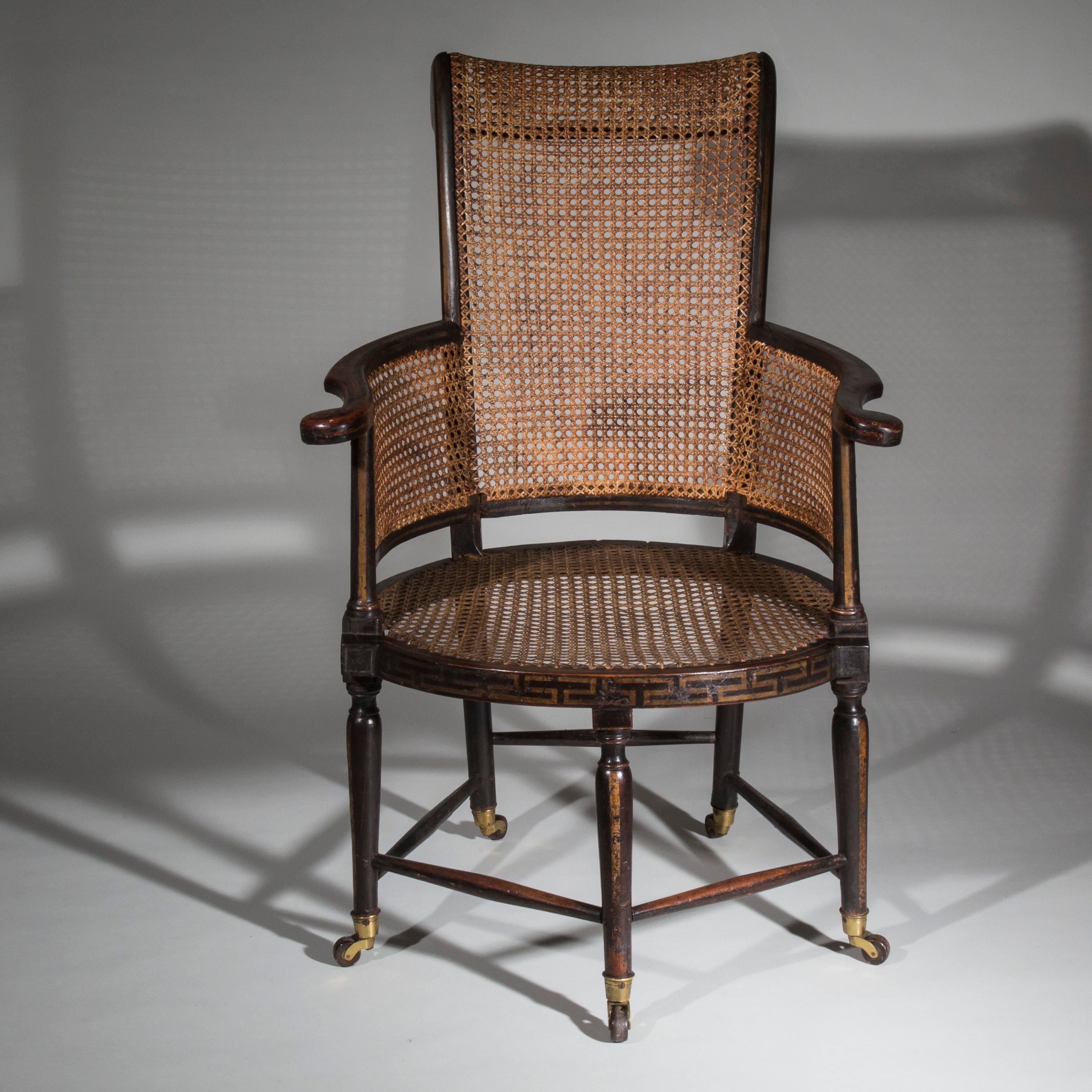 An extremely unusual early 19th century caned bergere armchair, monochrome black japanned and decorated in the Greek Revival taste with Greek key and scrolling volute motifs,

Possibly English or Irish, circa 1800.

The doyenne of what was to