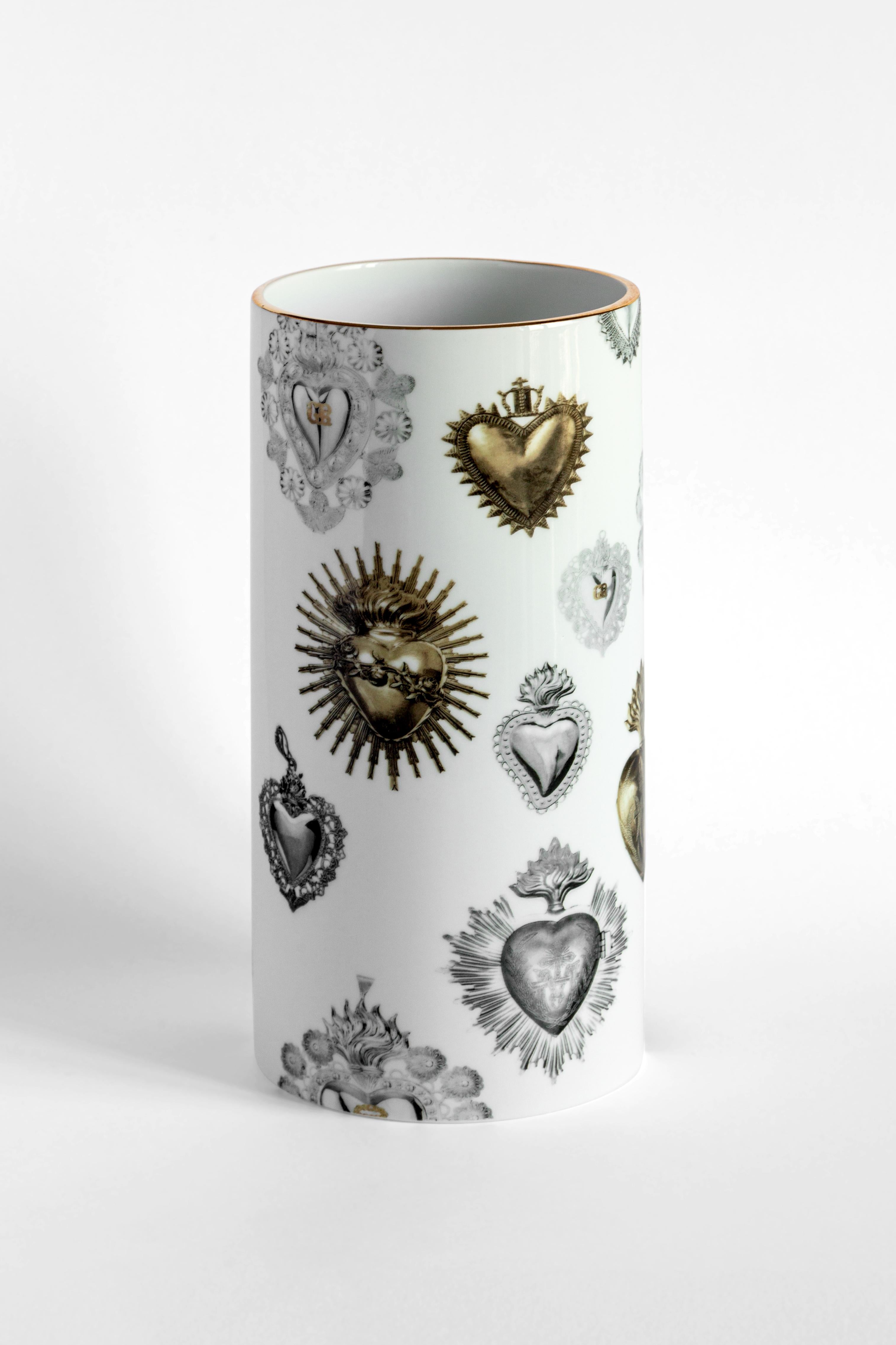 The cylindrical design of this porcelain vase is elevated and made unique by the application of a contemporary and unique decoration. This design is inspired by heart shaped ex votos, very popular in Italy and in the Mediterranean area. Votive