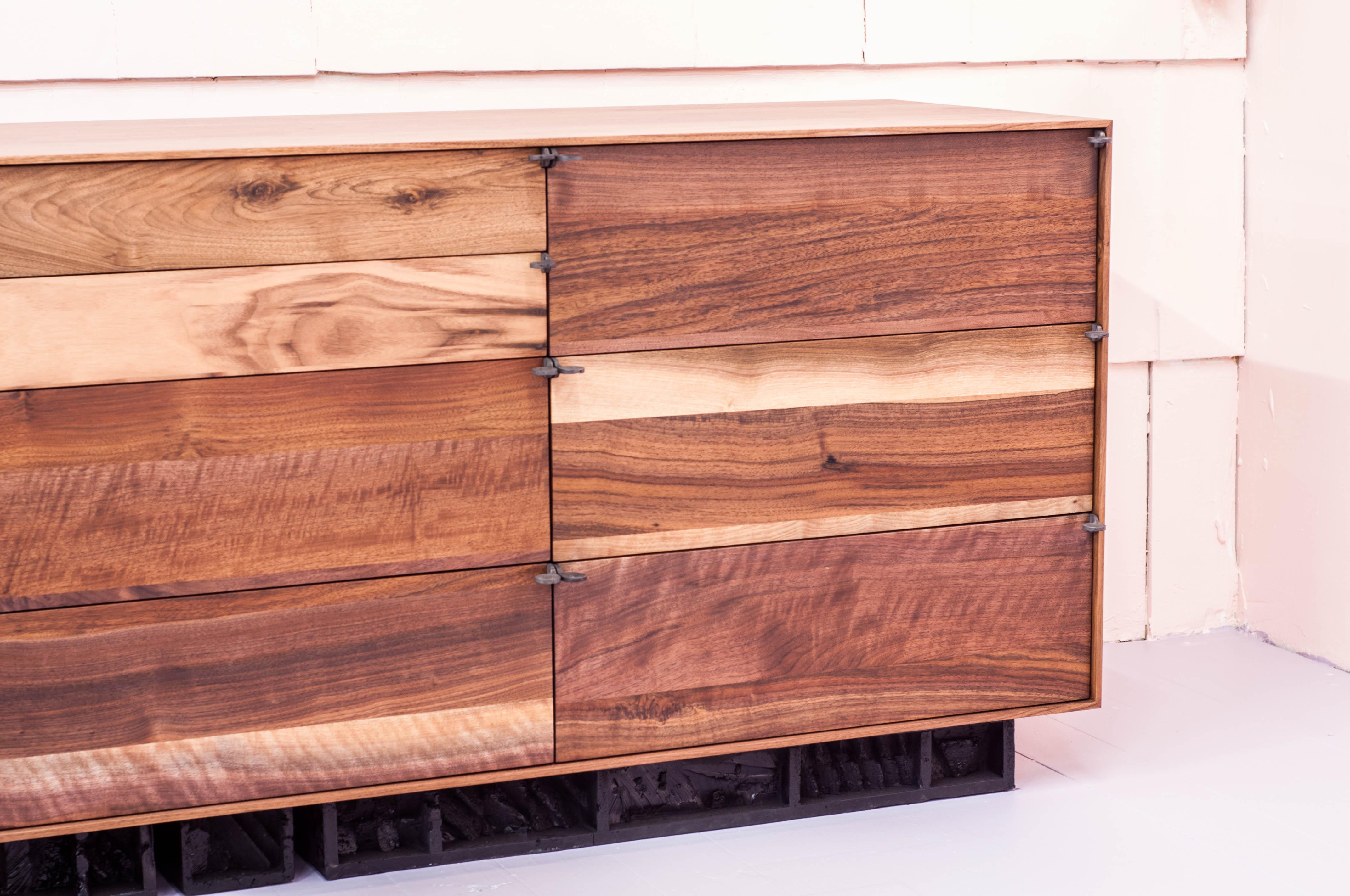10 drawer dressers executed in solid walnut, with a triple plinth Brutalist base and cast pewter petal handles.