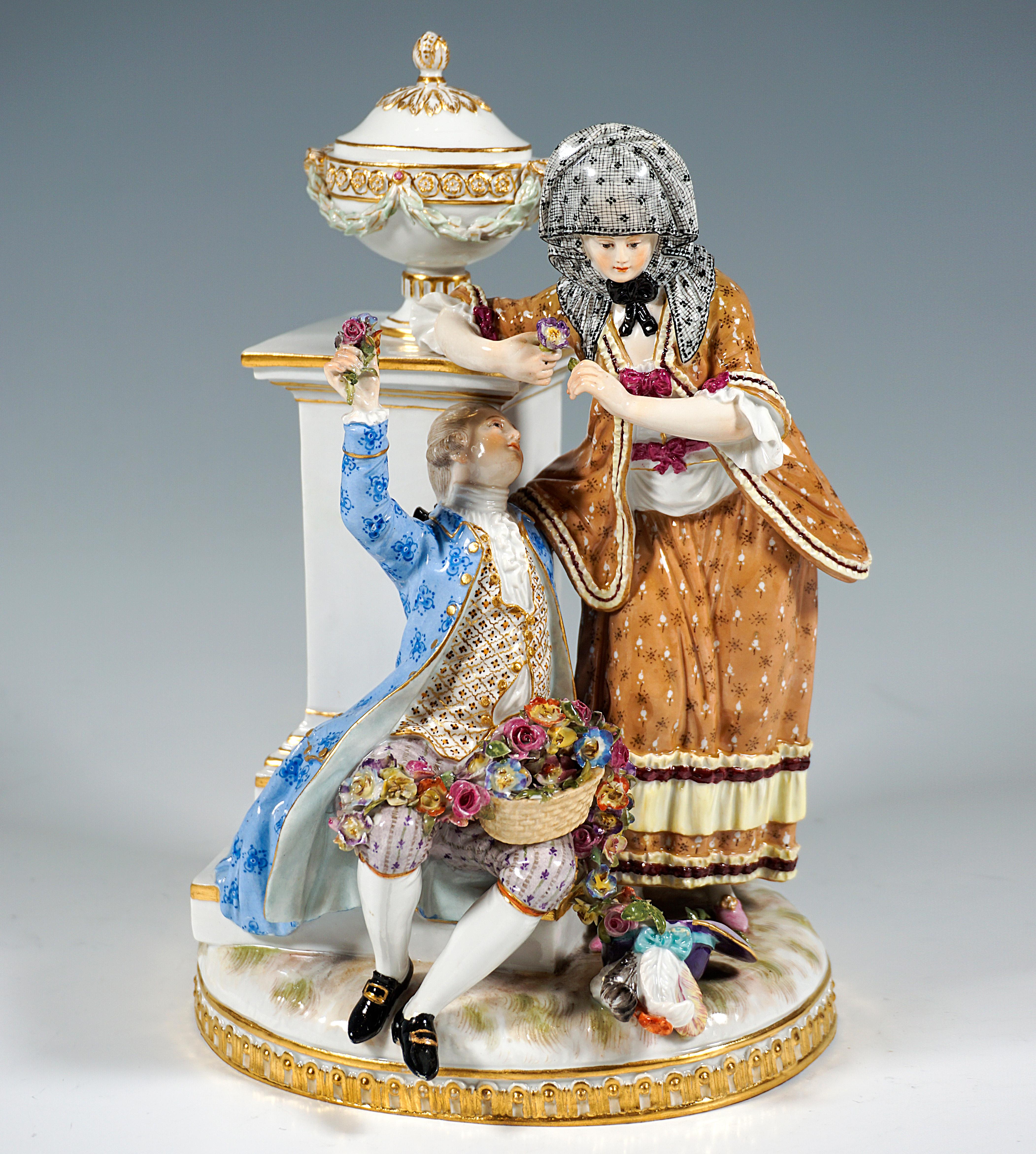 Excellent Rococo love group in splendid clothes in front of ornate column monument: the gallant sitting on the pedestal of the pedestal at the feet of his beloved, on his lap a basket full of flowers and a flower garland, a sign of his exuberant