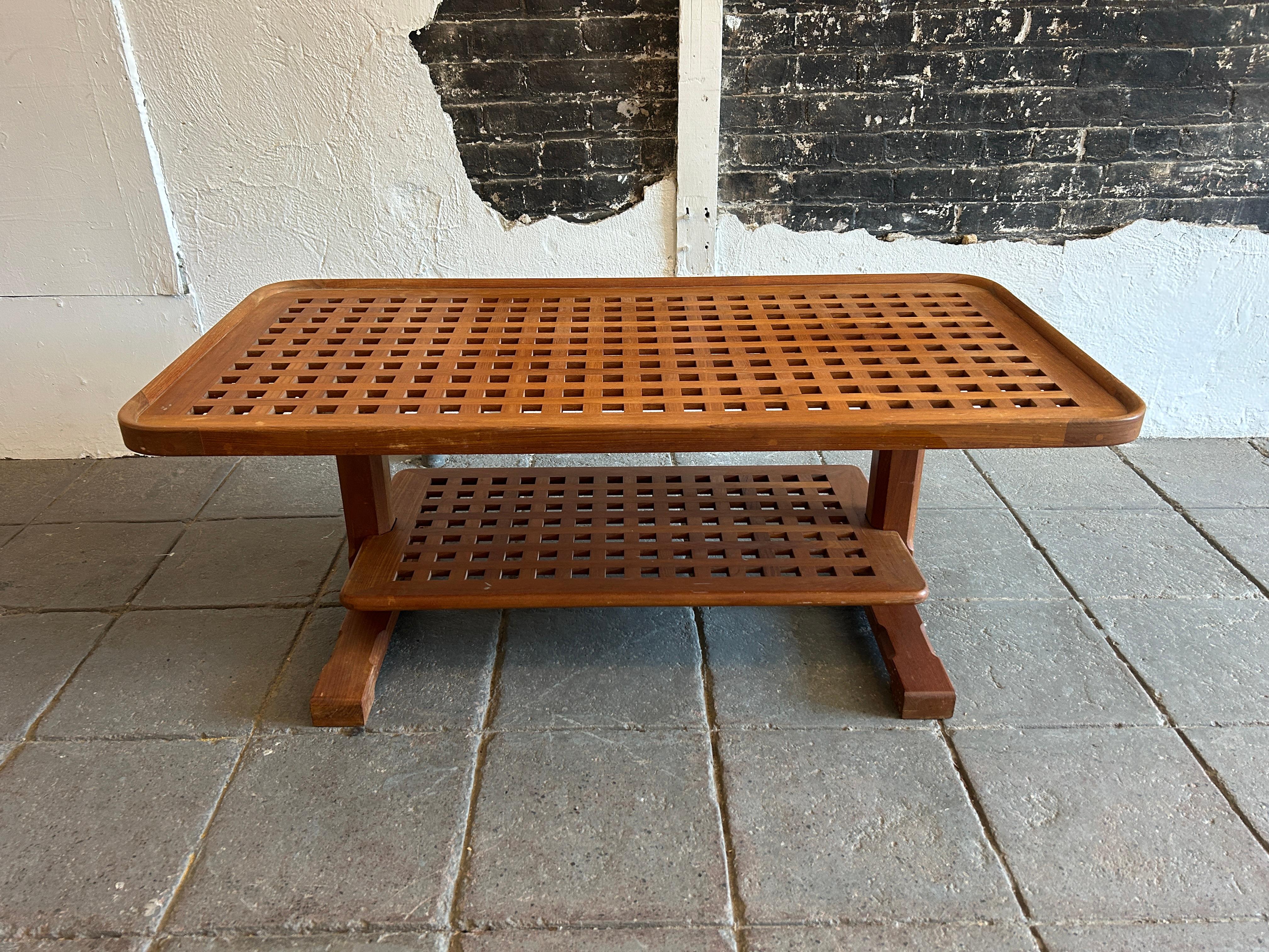 Excellent midcentury Danish Modern solid Teak Lattice 2 tier Coffee Table. Beautiful teak slat lattice and brass screws coffee table. Wonderful design in good vintage condition with a warm teak patina. Lower Shelf is removable. Located In Brooklyn