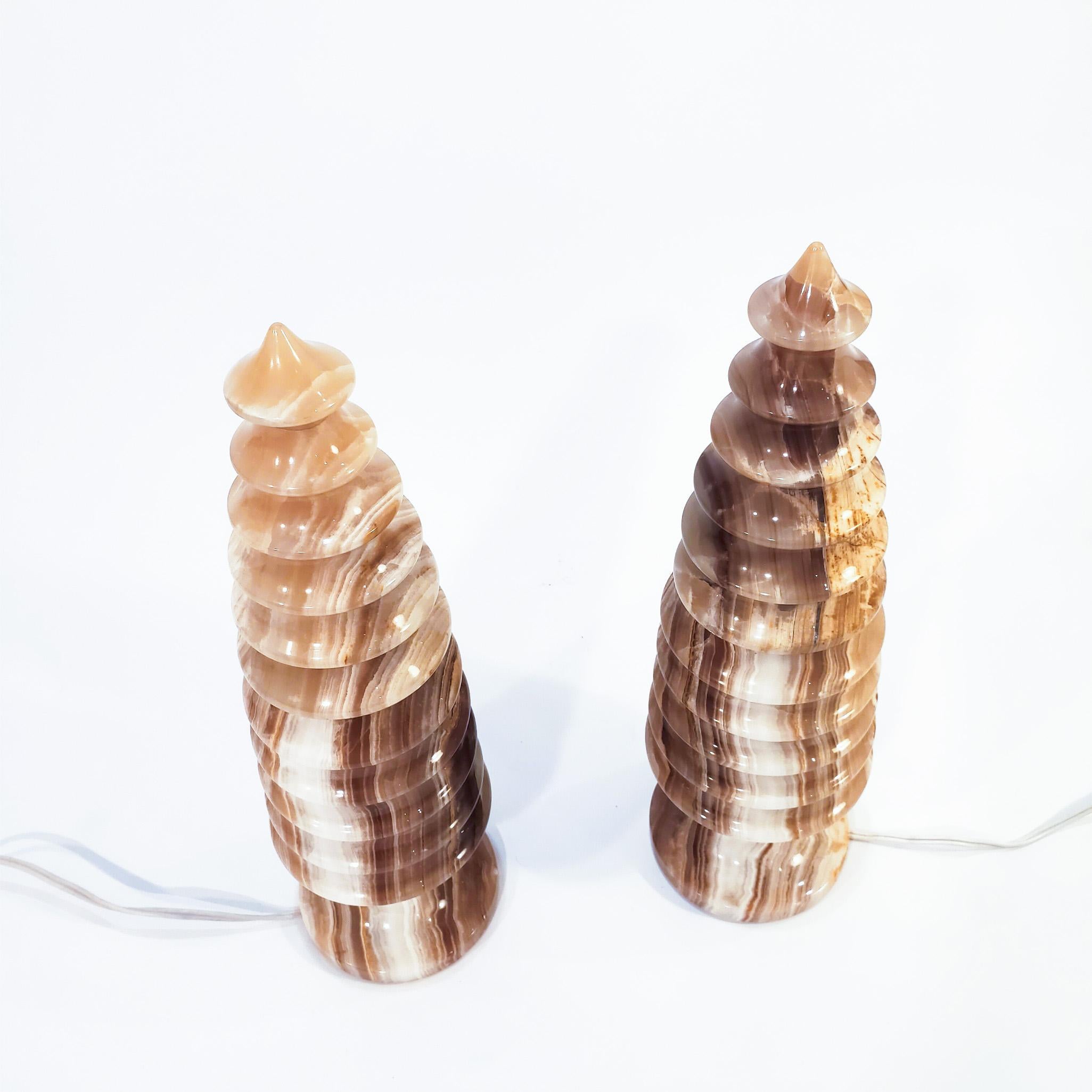 Pair of onyx table lamps produced and manufactured in Italy in the 60s. Each lamp is composed of 2 pieces in the shape of a Chinese pagoda. This exclusive marble and veined in multiple earth tones gives the pieces an exceptional beauty when they are