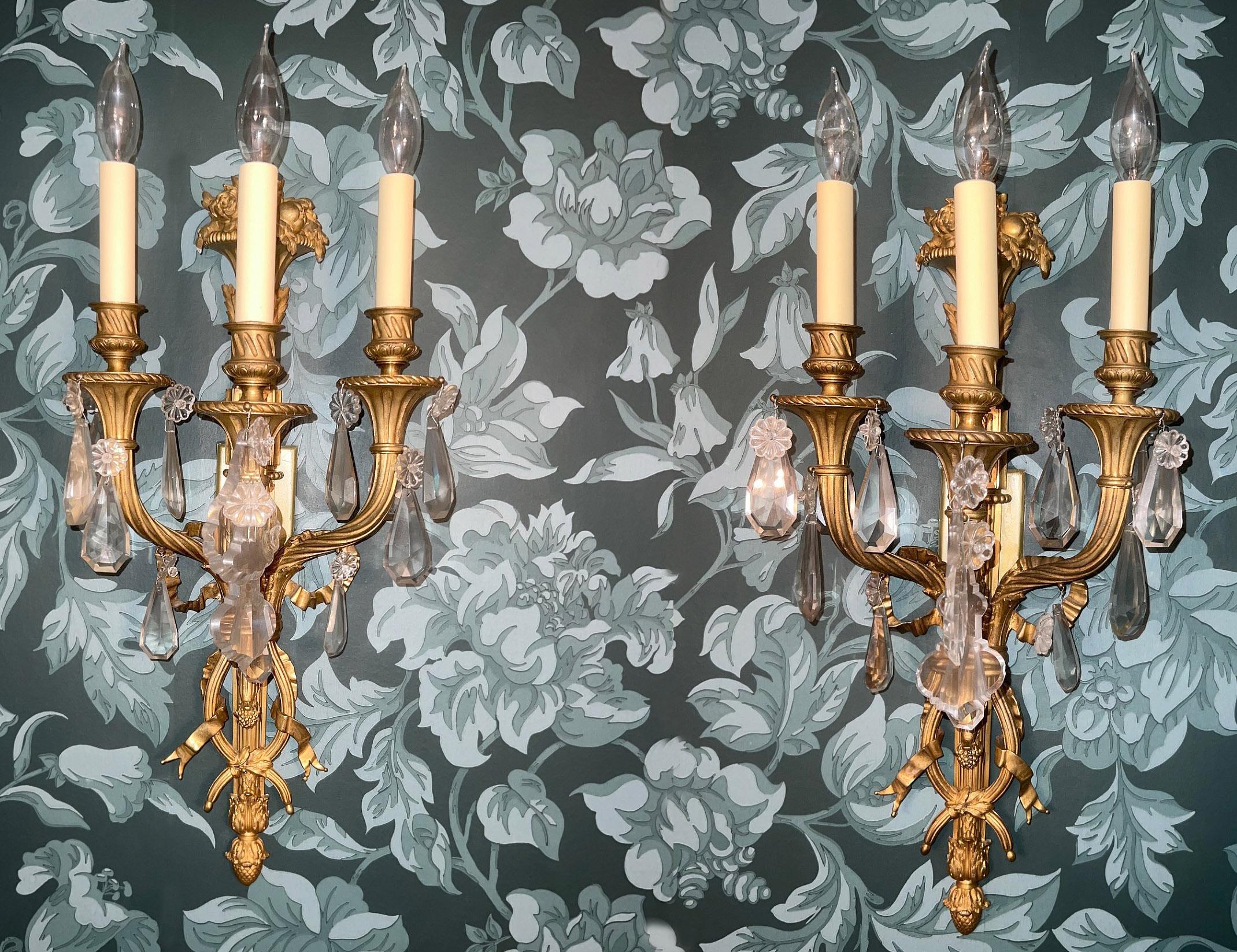 Excellente paire d'appliques à trois lumières en bronze doré et cristal de la fin du XIXe siècle

Chaque applique est surmontée d'une corne d'abondance remplie de fruits et de fleurs, la plaque arrière est centrée par un ruban noué qui descend le