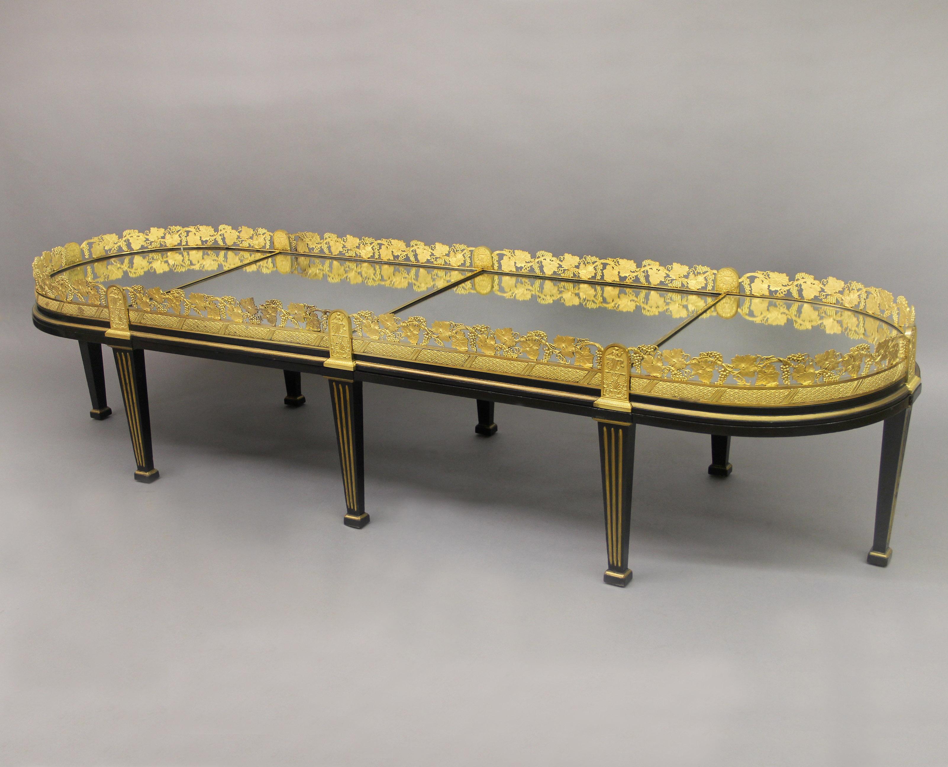 An Excellent Quality Mid 19th Century Gilt Bronze Four Piece Surtout De Table on Low Stands

This wonderful plateau cast with a grapevine bronze gallery, centered with a mirror base, and raised on an ebonized wood table. It can be used as a low