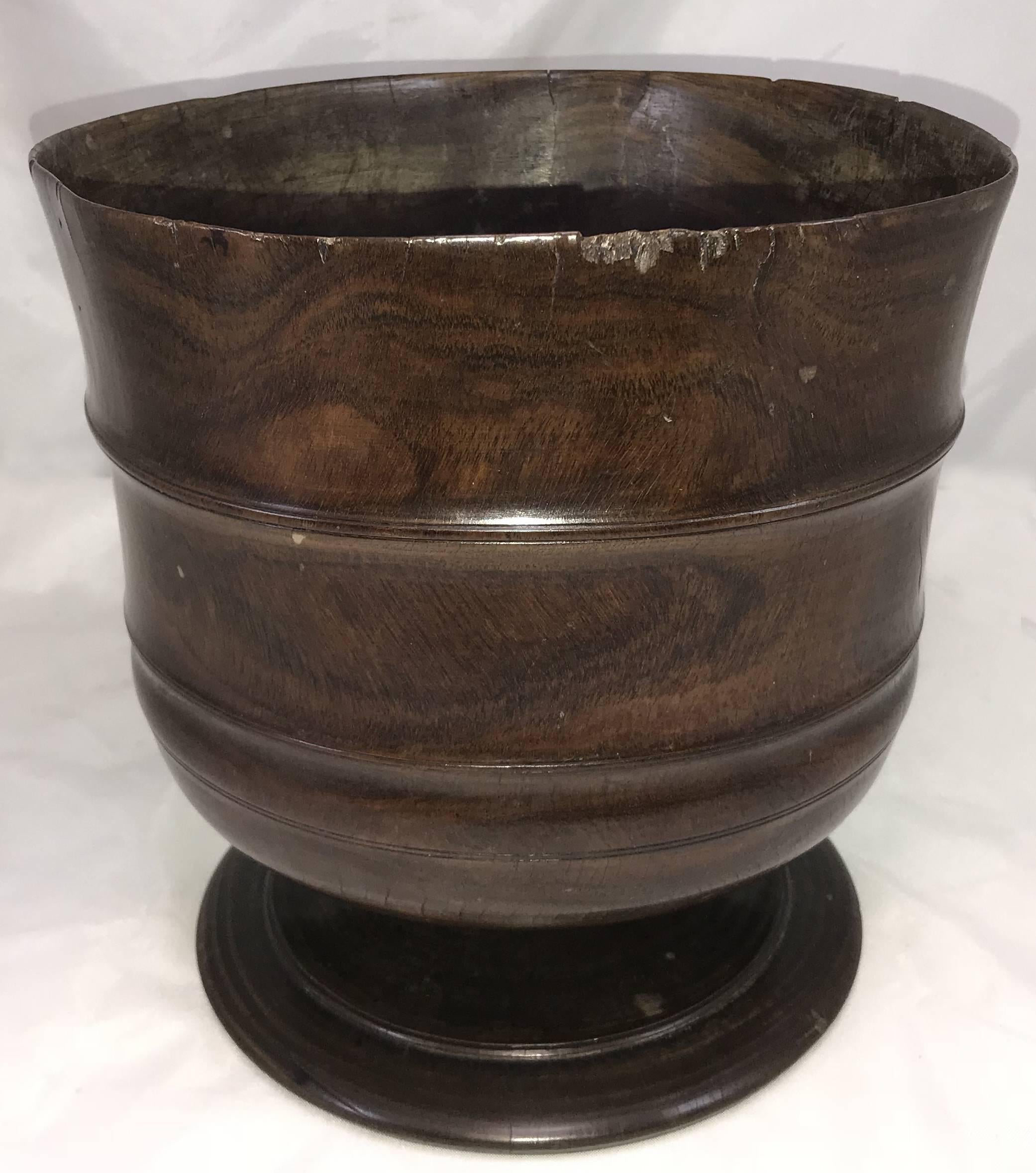 An exceptional example of a carved English Wassail bowl, circa 1680, in figured lignum vitae with incised band decoration on the bowl, supported by a wide carved foot, with great overall patina. The word 'wassail' comes from the Anglo-Saxon phrase