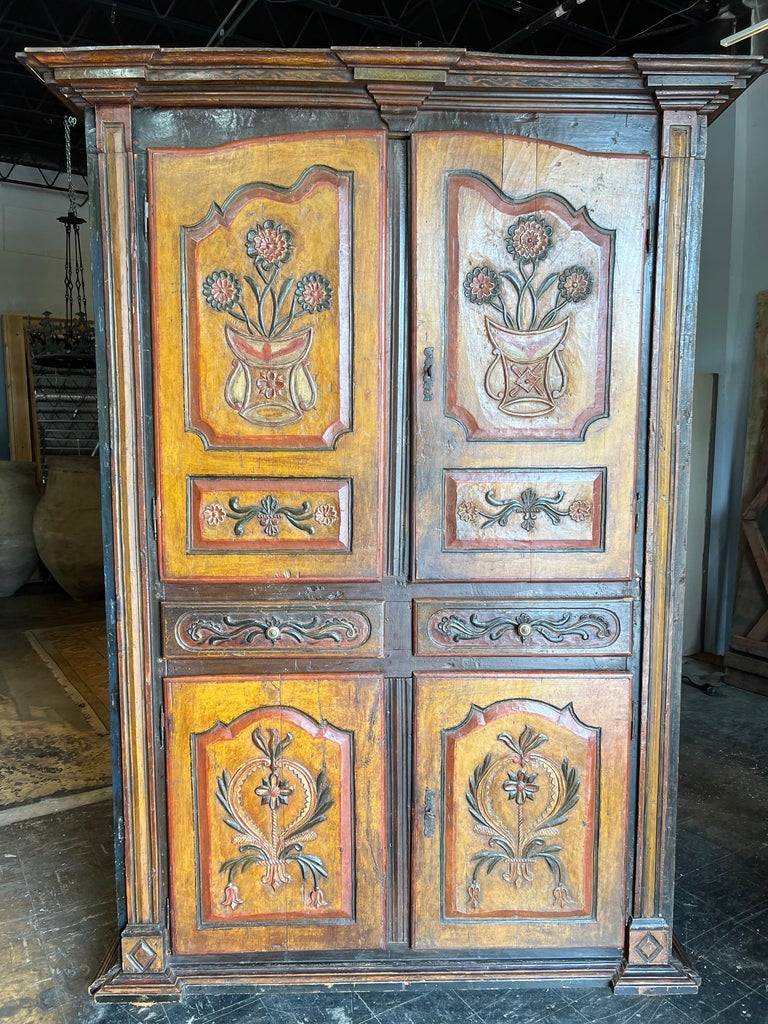 An absolutely outstanding and exceptional Armoire A' Quatre Portes - 4 door Armoire from the Dolomite region of Italy. Expertly crafted with 4 doors and 2 drawers resting on flat bun feet. Beautifully carved. Each door panel is carved from a solid