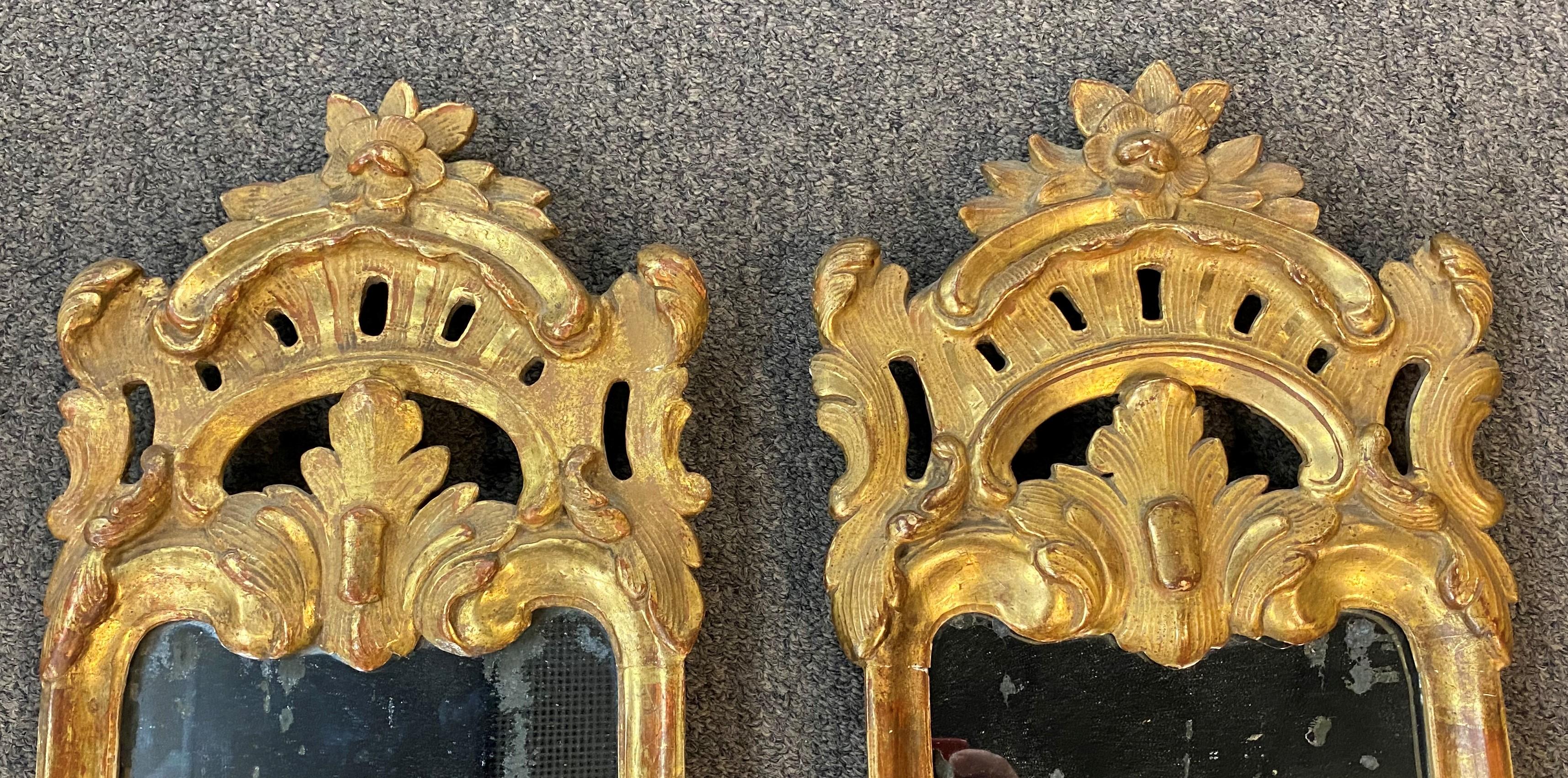An exceptional pair of gilded Girandole mirrored wall sconces, likely Swedish, with brass candle arms, and original looking glass. The back of each shows and inscribed label, one with “Georg” and the other “Le Major Castiller Grenier (sp?)” The pair