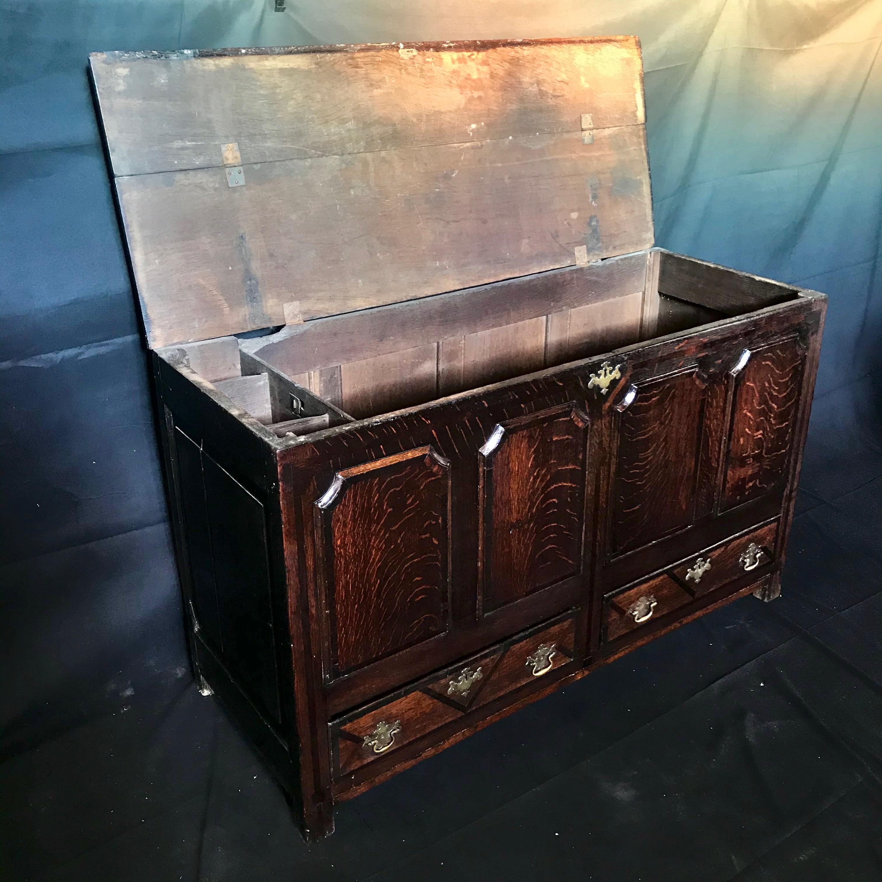 An exceptionally handsome 18th century British mule chest having a beautifully carved top section, flamed oak and inlaid drawers at the base with a very good patina and color. 
#3472.
 
