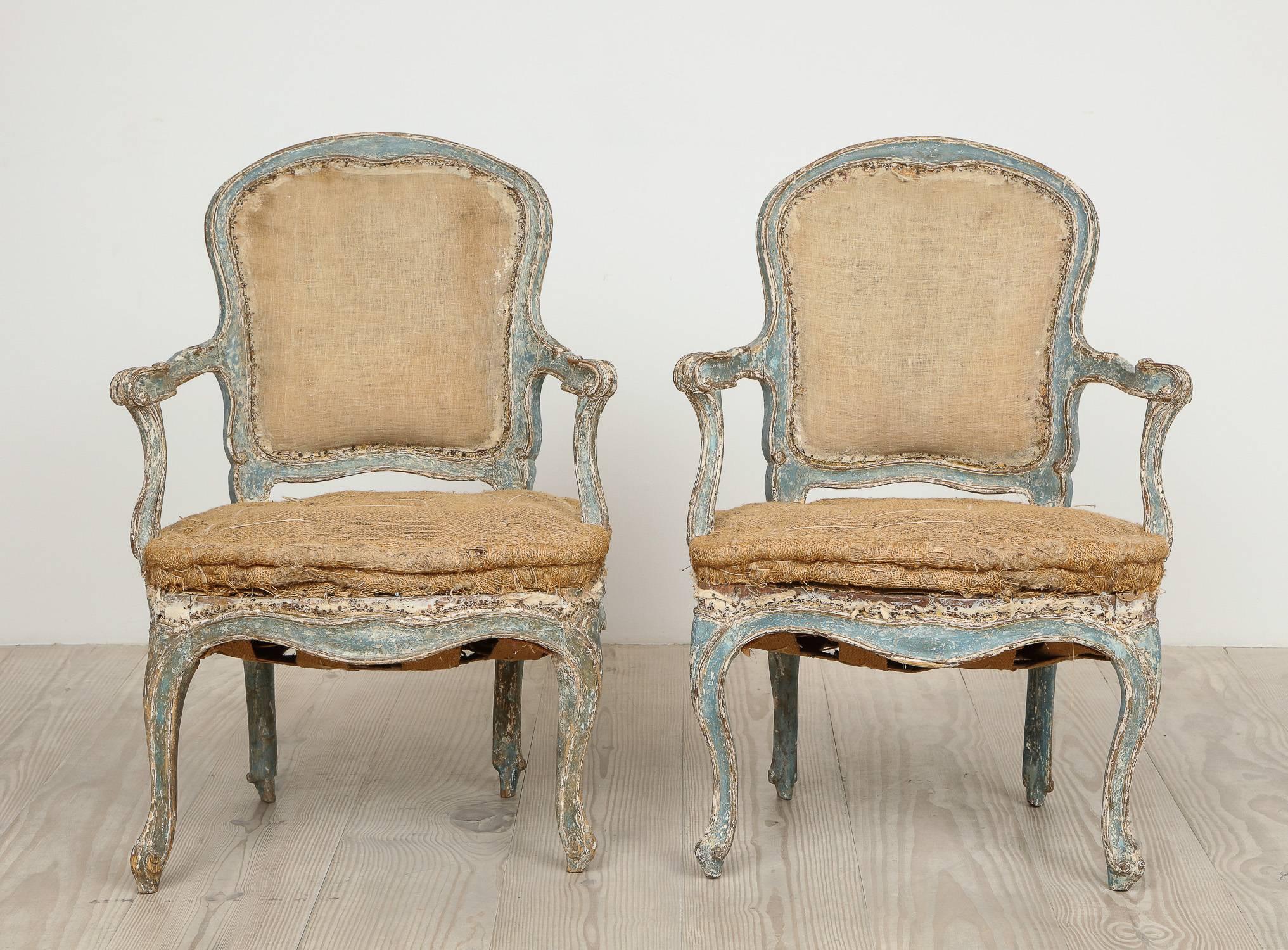 18th century rococo armchairs, pair, circa 1760 with original blue color and remnants of silver giltwood; wonderful forms with gorgeous carvings.