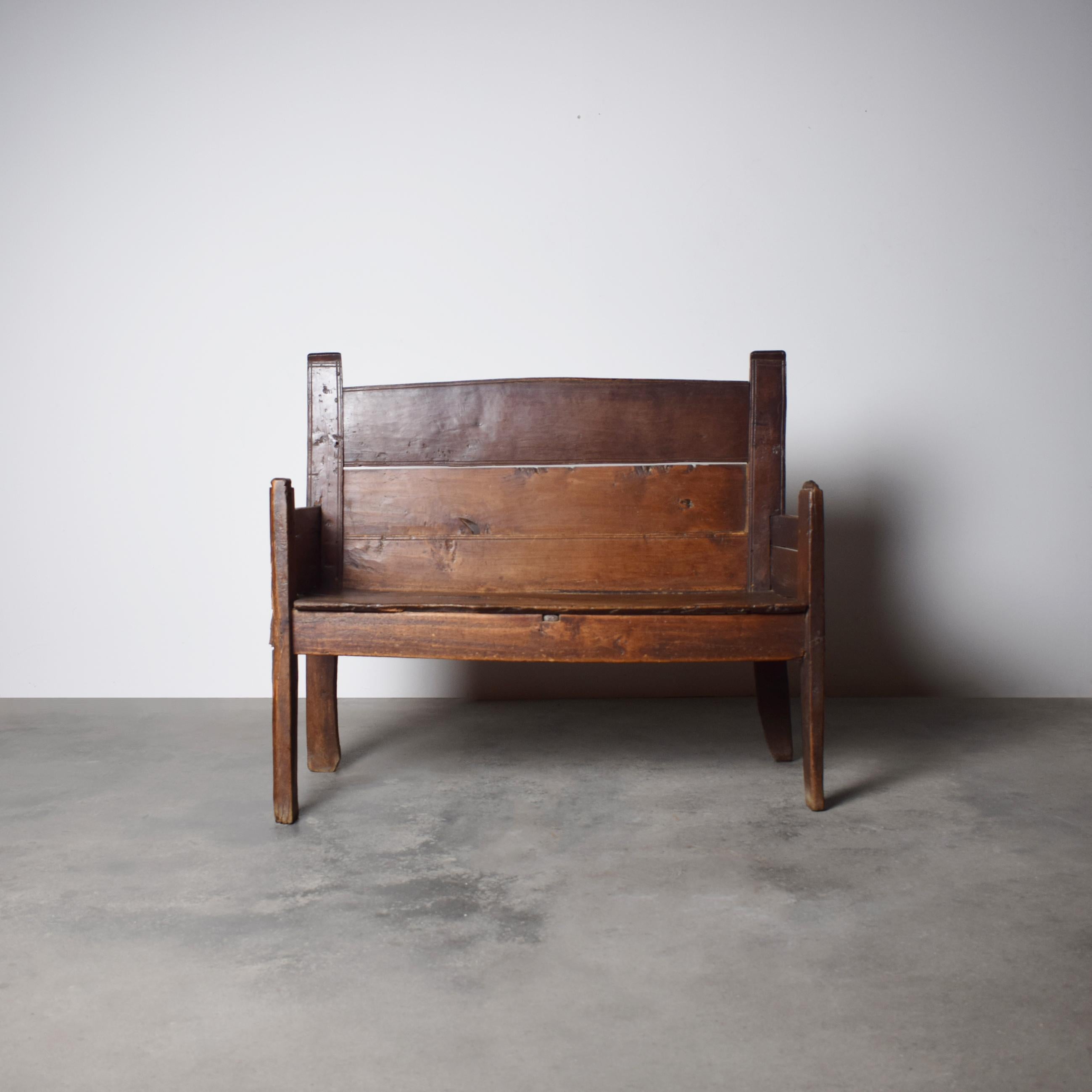 This rustic handmade Spanish Two Seater bench, crafted from solid chestnut wood, dates back to the 18th century. Showcasing the charm of traditional Spanish craftsmanship, it features a simple yet robust construction with a weathered patina that