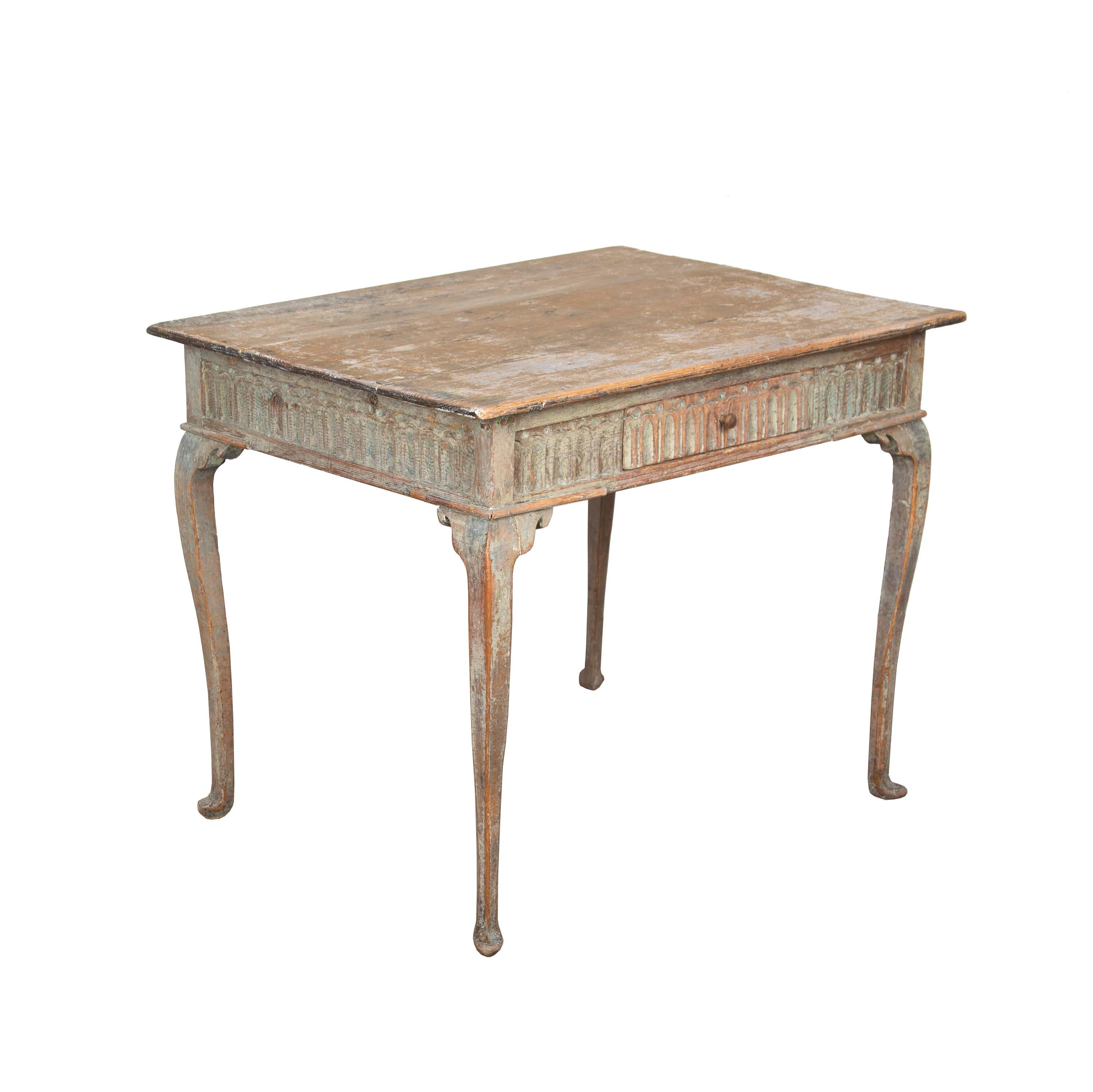 Exceptional period 18th century period table from Finland - scraped to original paint. This piece features a square table top with curved edges, decorative carved stretcher with the carving going all around the table, and four cabriolet legs