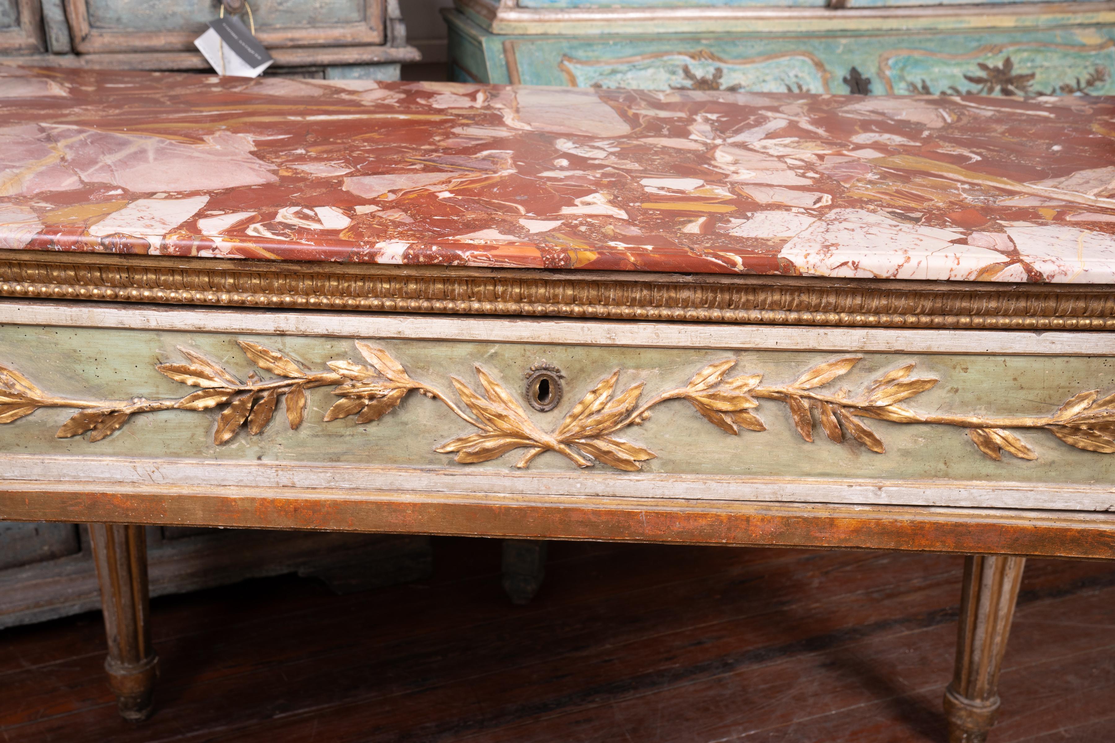 I present a fantastic 18th century painted and gilded Roman Console with a rare Italian marble top. This marble is no longer mined  but it is in the family of Il Marmo Rosso Agadir.This console shows the finest 18thc carved wood elements with parcel