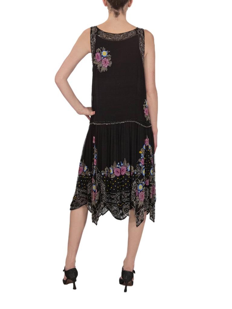 Exceptional 1920s Black fine silk chiffon plissé flapper dress with unusual handkerchief hem hand-beaded throughout with miniature glass beads arranged in a spring flower bouquet and garland design in shades of pink, green, blue and yellow bordered
