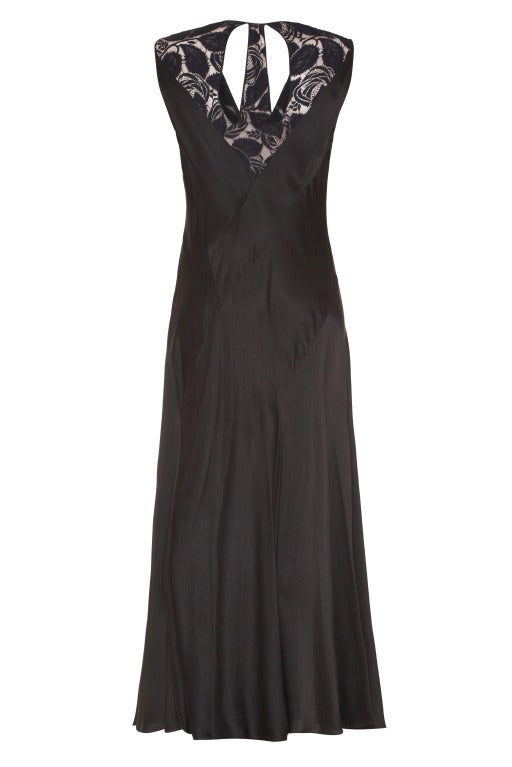 This stunning 1930's black liquid satin silk evening dress is in excellent vintage condition with a superb bias cut construction.  It has a crossover V neckline in a stylized Art Deco rose print lace overlay which is lined in a nude silk chiffon.