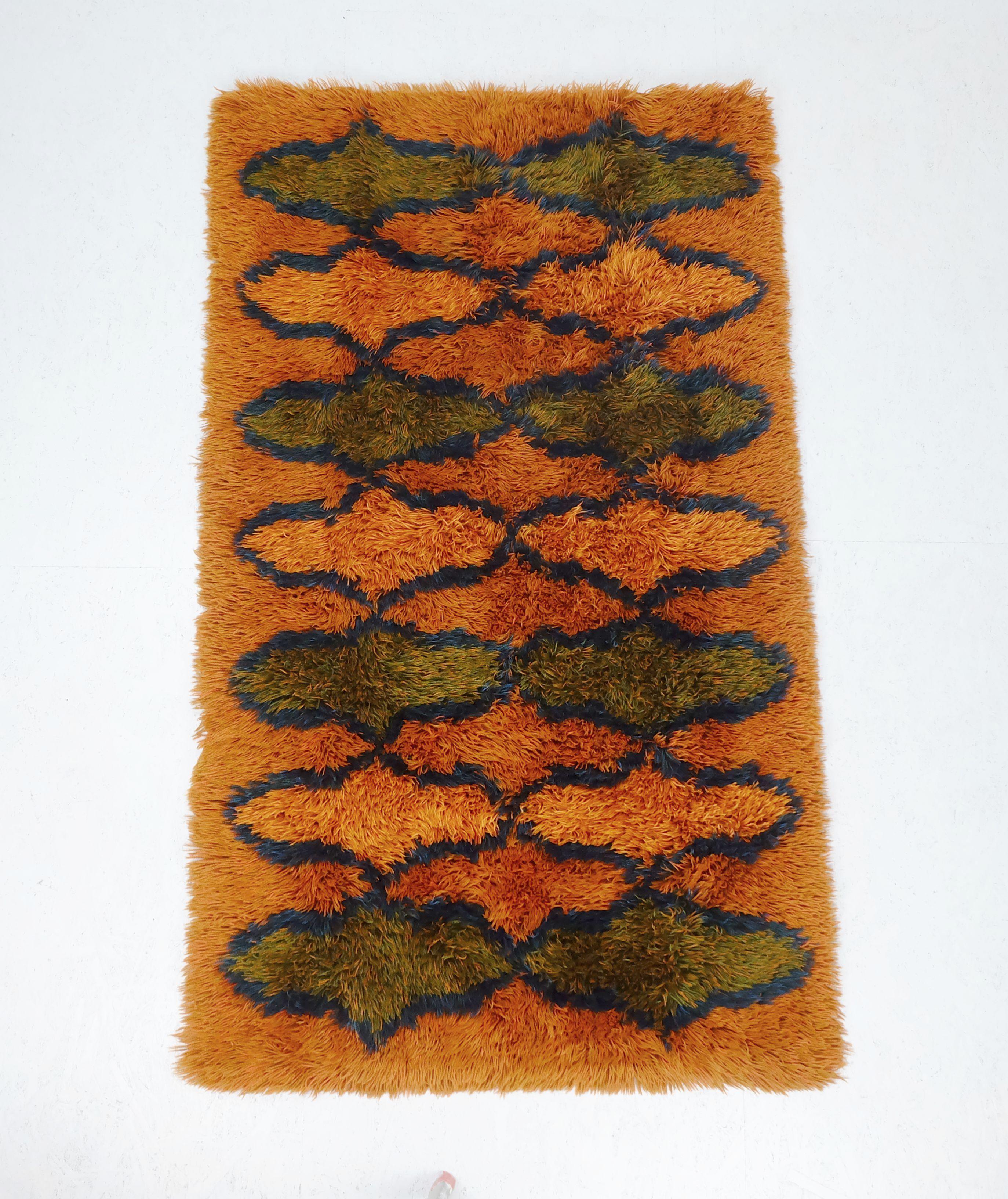 A very beautiful and decorative hand-knotted 1970s rug. Fantastic and typical 1970s combination of colors: different shades of orange and green combined with dark blue. Made of wool. A perfect addition to any mid century or op art pop art interior.
