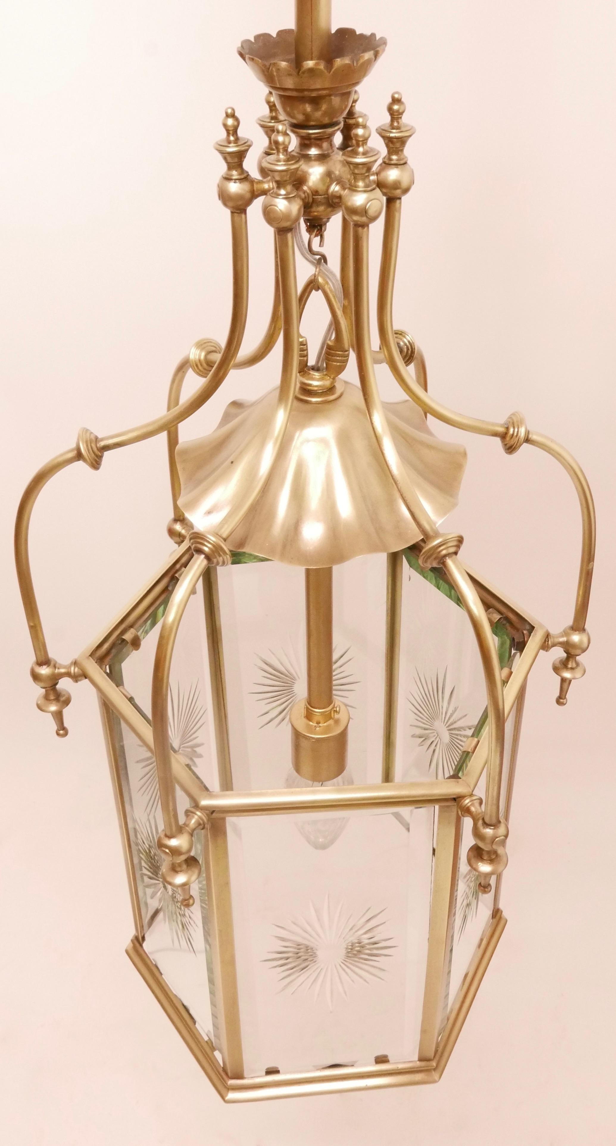 An exceptional brass and cut glass hanging entry hall or stairwell lantern, originally gas operated and recently converted to electric.
The hexagon shaped lantern has beveled glass panels with centered cut glass starbursts. 

American, late 19th