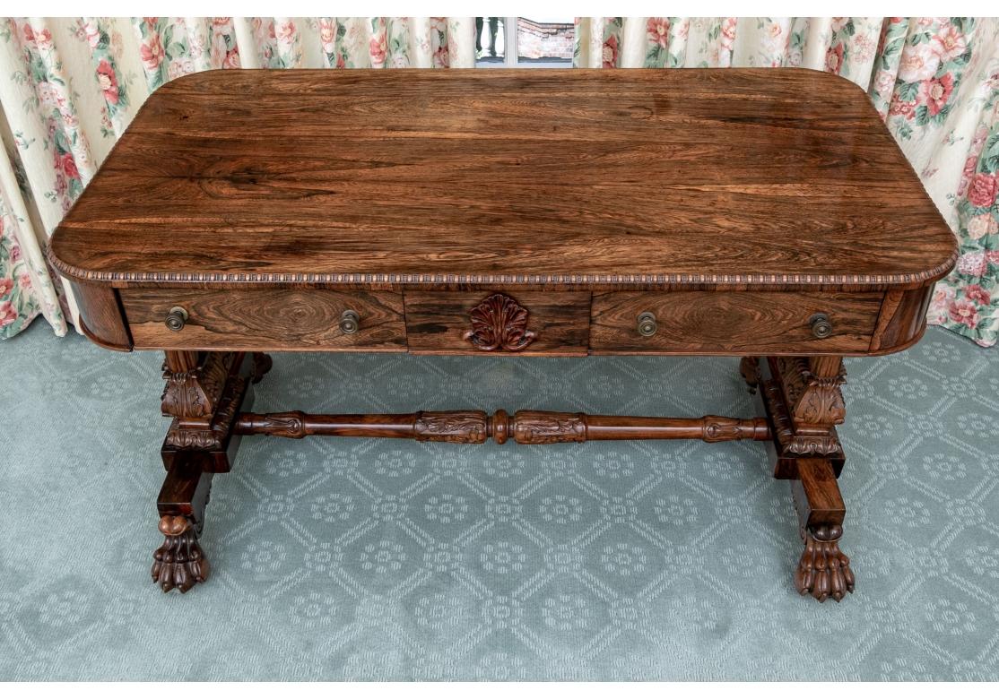 Provenance: Christies. rectangular with curved top ends and carved bead-and-reel edge. The apron with one short and one long drawer that includes the carved leafy center motif. Both with fine brass knob pulls. Raised on an elaborately carved base