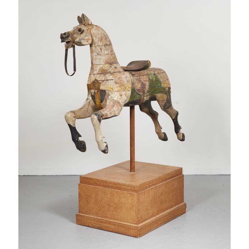 An exceptional carousel horse in original paint depicted chahut (prancing). Expressive face and features including eyes and blinkers, mane, saddle and chest harness and hooves. Weathered and mellowed original paint details. Now displayed on custom