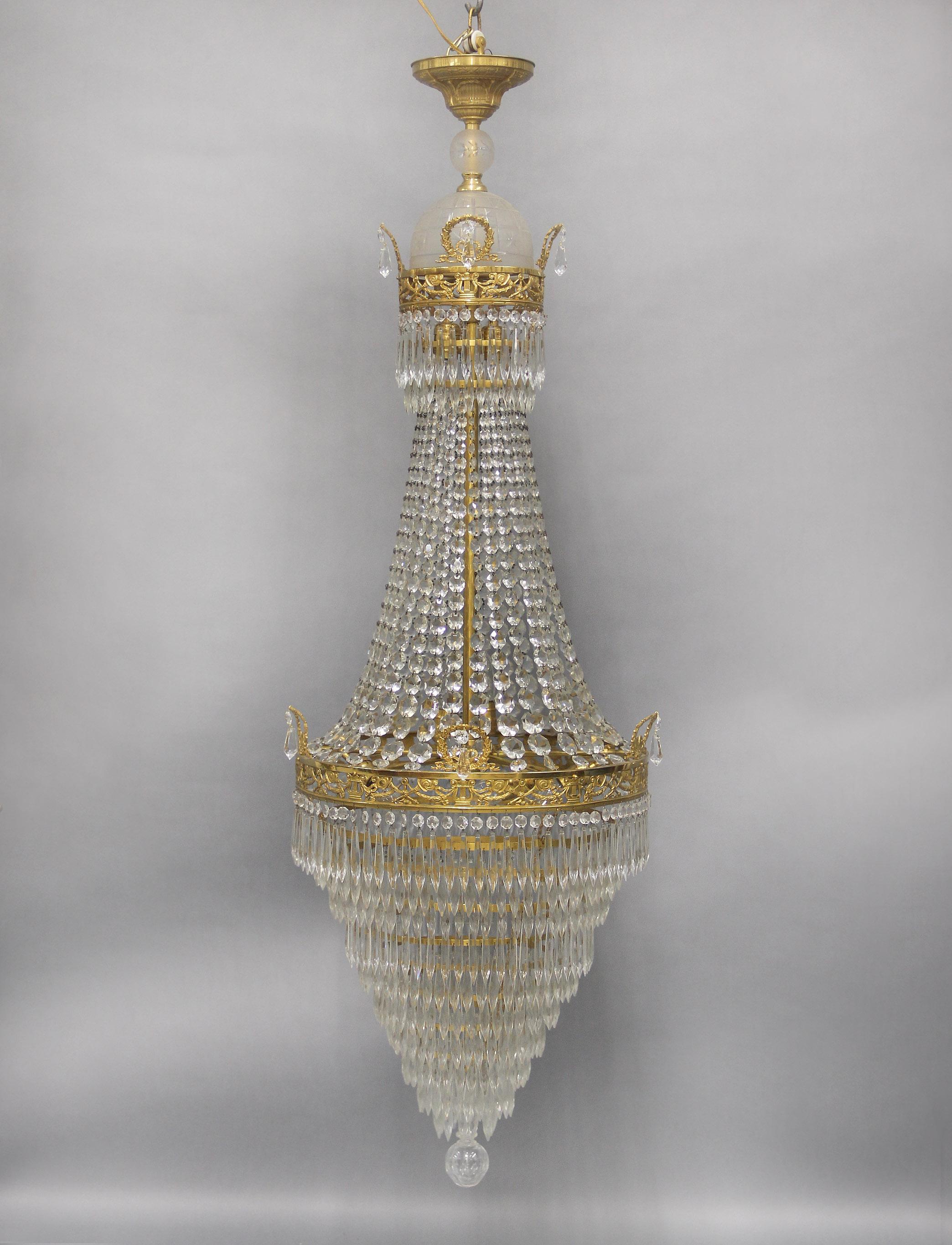Eccezionale lampadario di fine Ottocento in bronzo dorato e perline a sette luci in stile impero russo con cristalli a goccia

La bellissima corona con una sfera e una cupola di cristallo inciso sfumato, sopra un bordo di bronzo disegnato con torce
