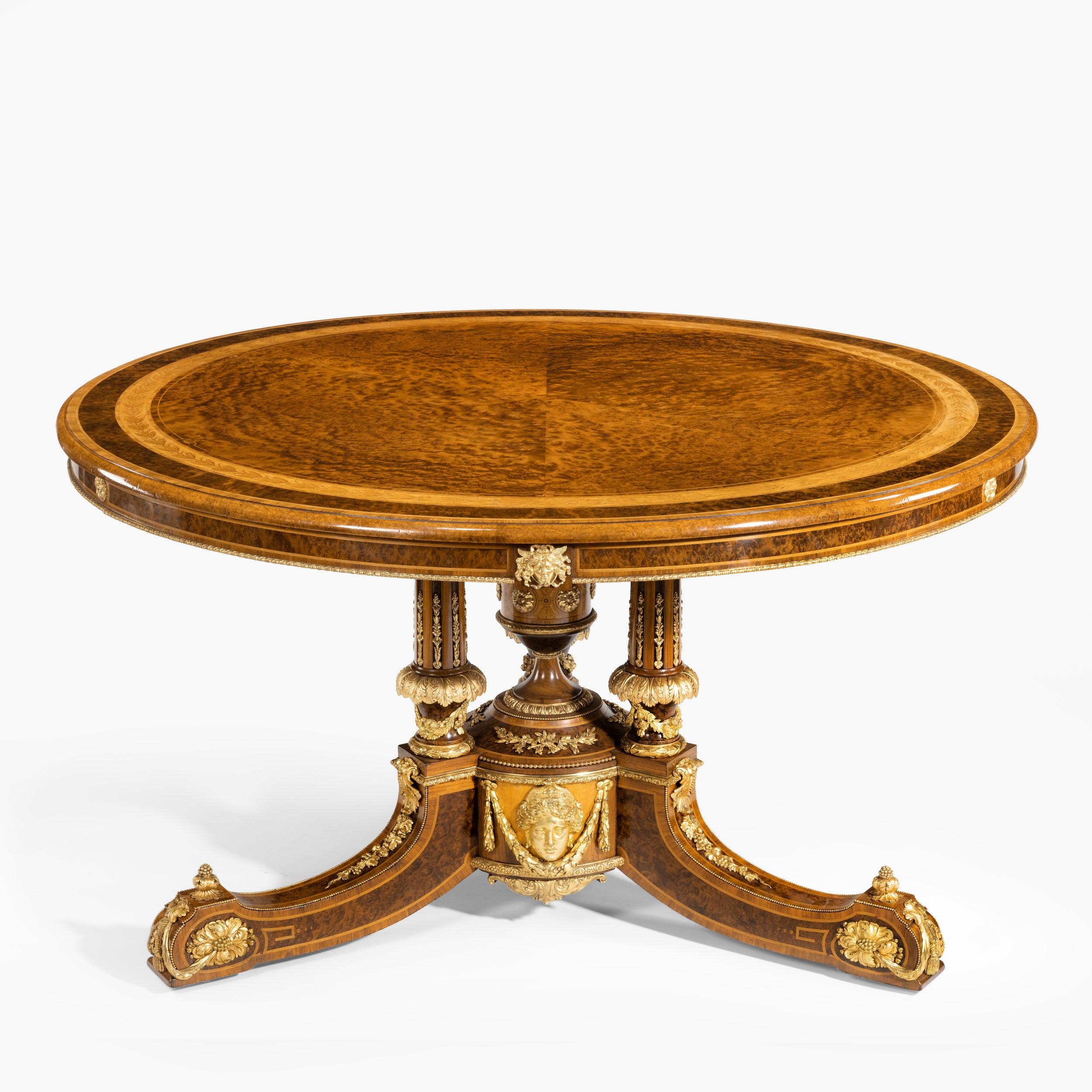 An exhibition quality table
 by Holland & Sons

Constructed in thuyawood, with satinwood and tulipwood used in the cross banding and inlays, and having finely cast ormolu mounts used in counterpoint; the tripartite downswept legs terminating in