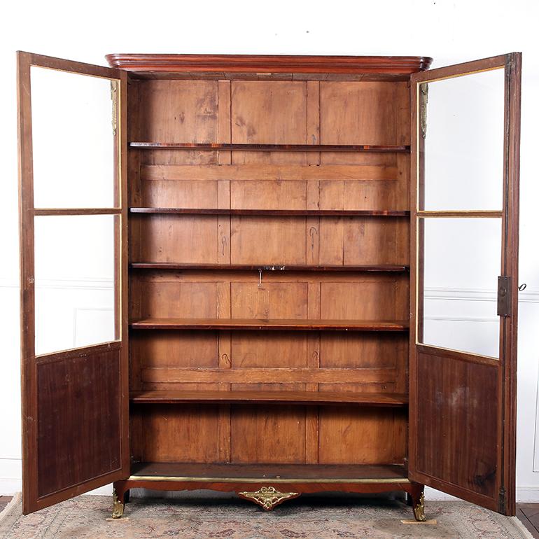 19th Century French Louis XVI style bookcase. Exquisite marquetry in rosewood and kingwood. Adorned with original gilt bronze mounts. There are has five adjustable shelves. This rare piece has a depth of 13″ very practical and