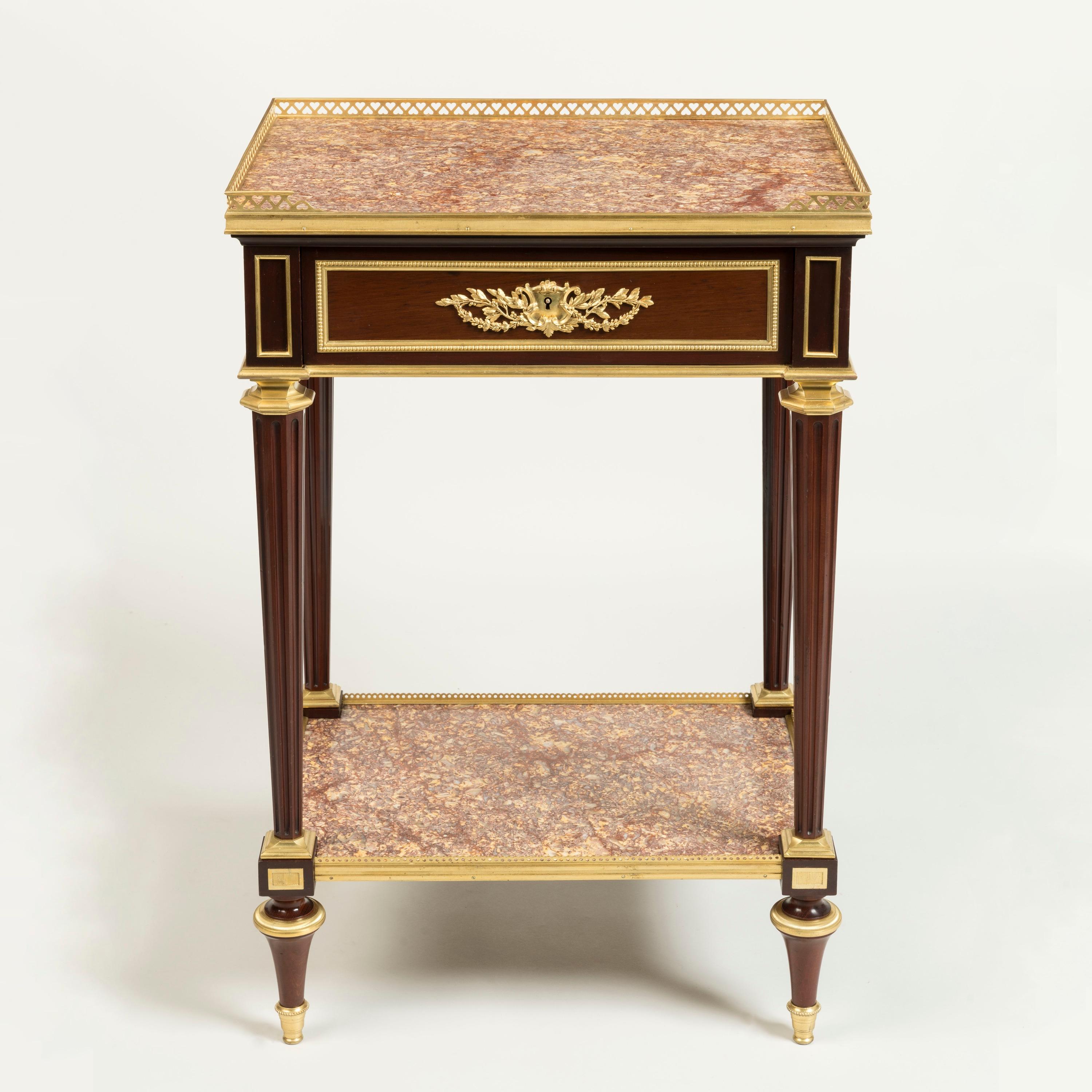A Fine Occasional Table
By Henry Dasson

Of rectangular form, constructed in mahogany dressed with finely cast and chased gilt bronze mounts; rising from ormolu mounted toupie feet, supporting the lower platform set with a brocatelle d'Espagne