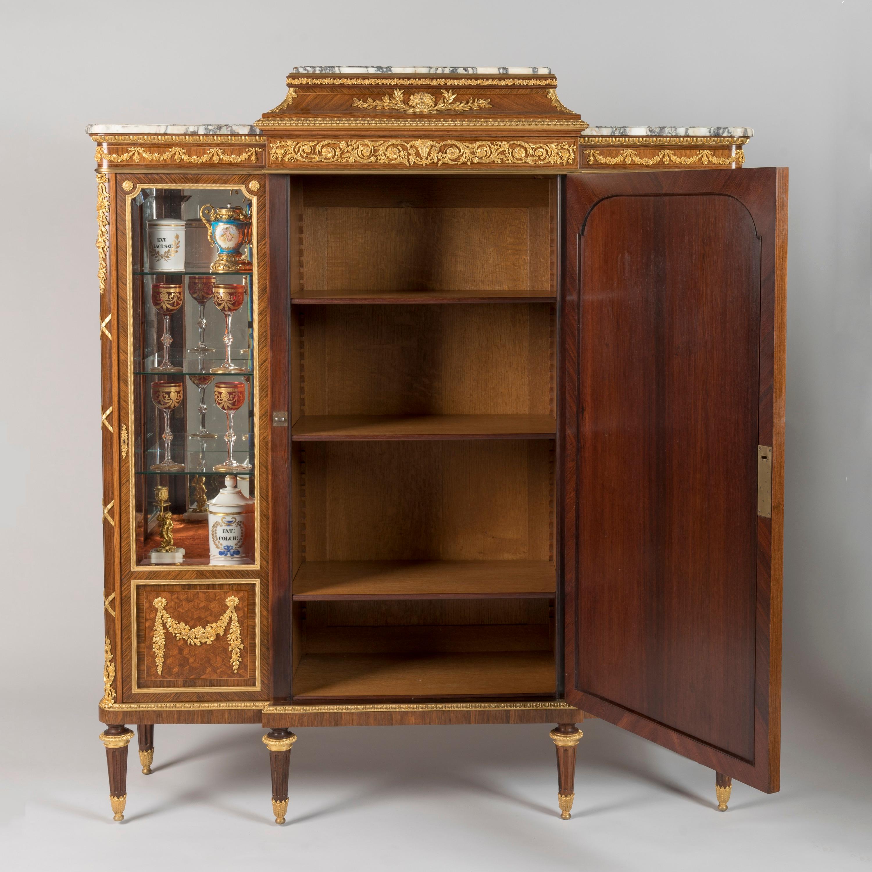 An Exceptional Louis XVI Style Vitrine Cabinet
By François Linke

Index no. 421

Of elegant breakfront form, surmounted by a stepped pediment top inset with three shaped and moulded breccia marble slabs within an egg-and-dart moulded surround, the