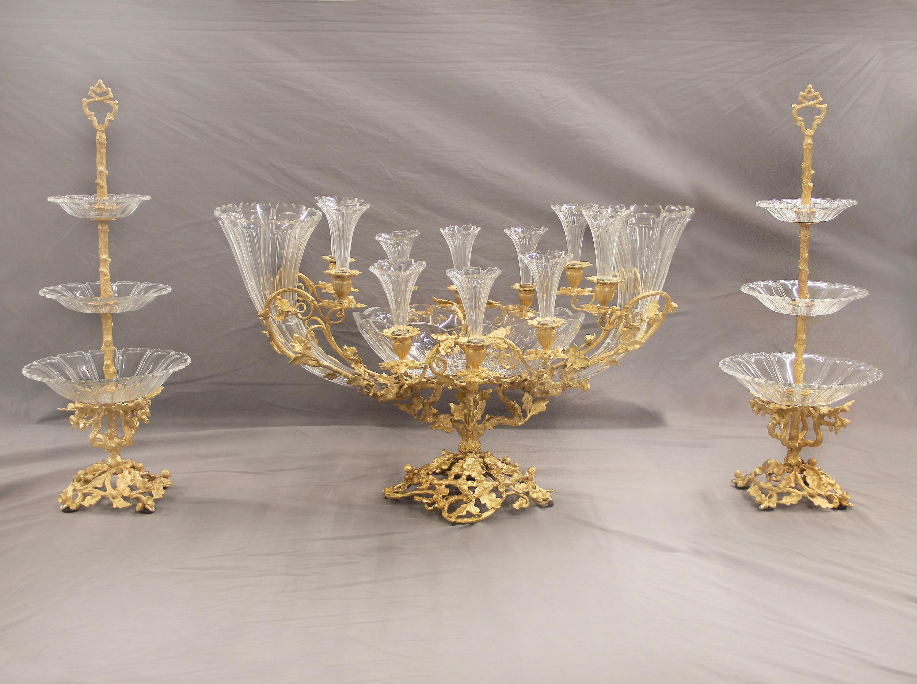 Grande et exceptionnelle garniture de table à trois pièces en bronze doré et cristal taillé de la fin du XIXe siècle, par Baccarat

Compagnie des Cristalleries de Baccarat

Comprend un grand centre de table et une paire d'étagères.

Le centre de