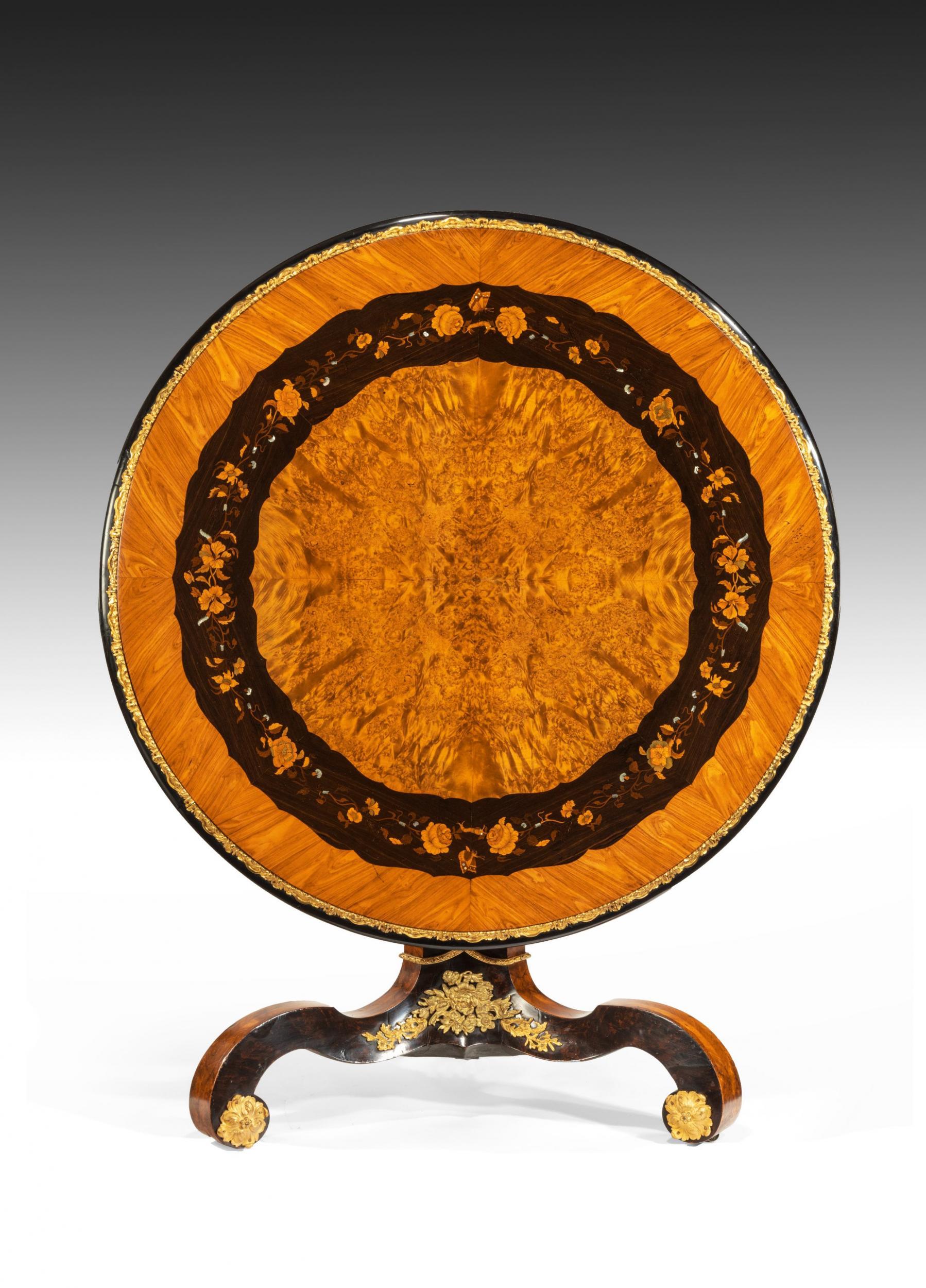 An exceptional marquetry and ormolu centre table of exhibition quality attributed to Edward Holmes Baldock. 

English, circa 1840.


Finely constructed, the burr maple circular hinged top with an ebony band enclosing a marquetry chain of