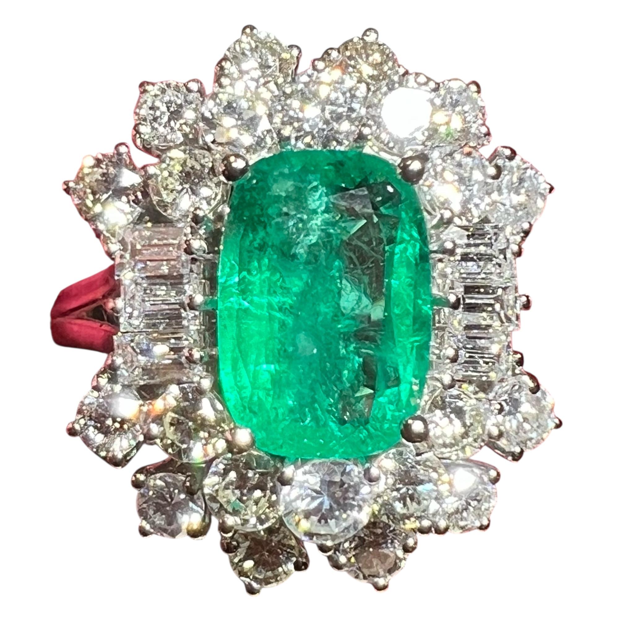 Exceptionnelle bague à émeraudes et diamants de remarquable facture française, vers les années 1960.
En son cœur se trouve une émeraude d'un vert vif, pesant environ 3,00 à 3,50 carats, avec un éclat cristallin brillant et une légère nuance bleutée
