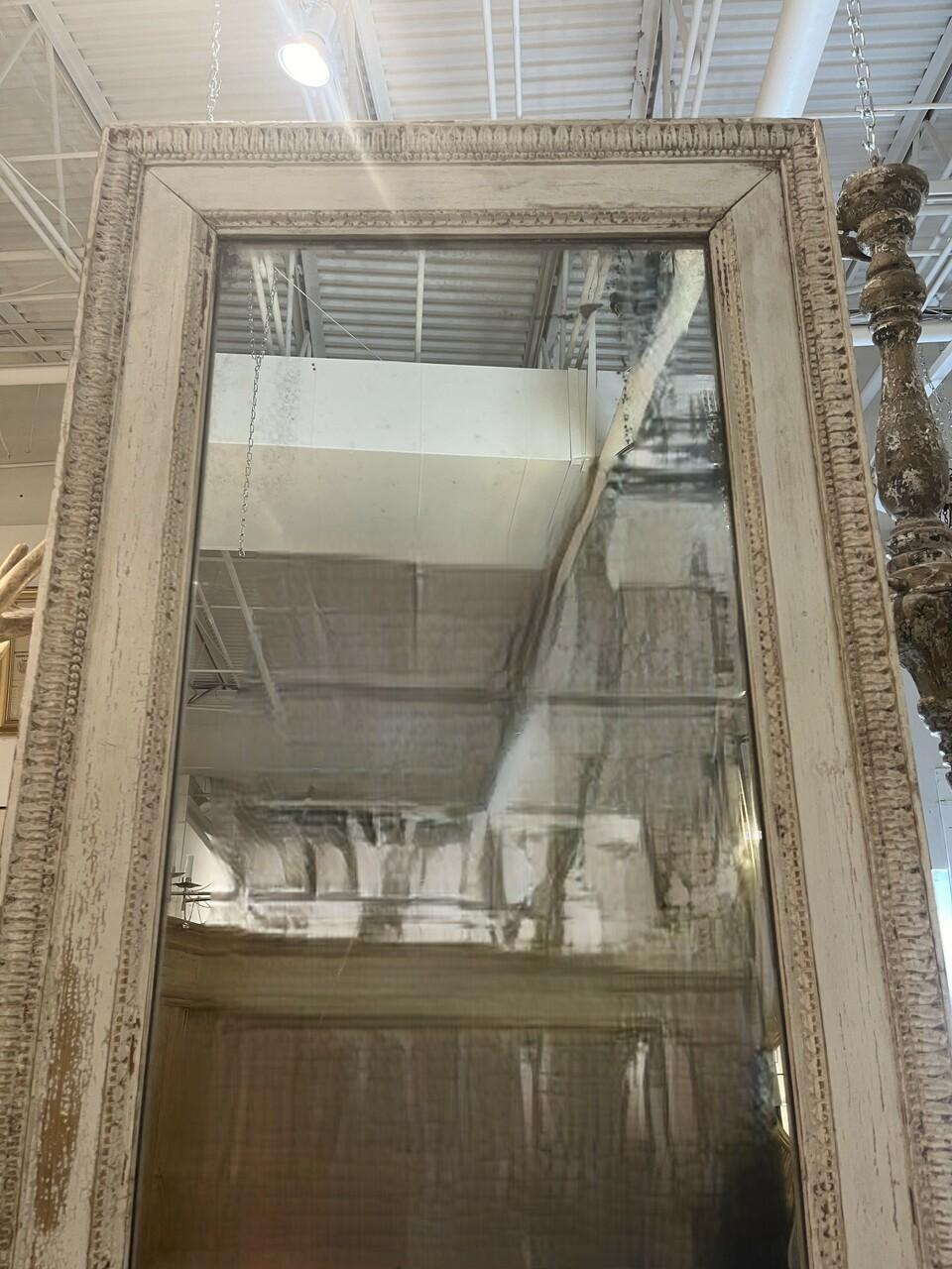 A beautiful piece of history in this hand carved and painted 19th century French mirror. An amazing nine feet tall with nice patina on mirror as well as the carved frame. Some paint loss and chips as to be expected with age.