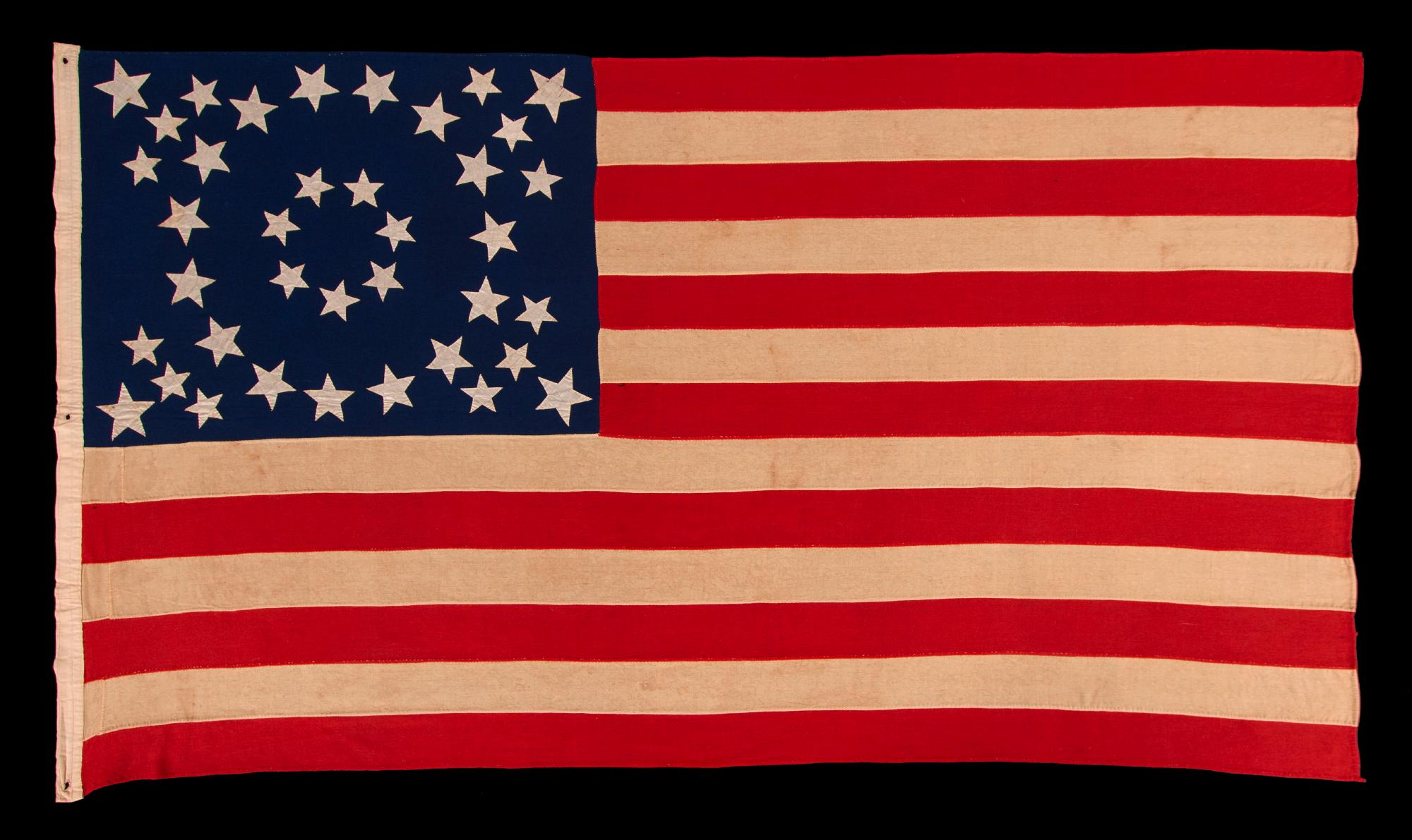 EXCEPTIONAL ANTIQUE AMERICAN FLAG WITH 38 GLAZED COTTON STARS, IN 3 DIFFERENT SIZES,  ARRANGED IN A BEAUTIFULLY GRAPHIC, DOUBLE-WREATH  STYLE MEDALLION, WITH TRIANGLES OF 4 STARS IN EACH CORNER, LIKELY MADE FOR THE 1876 CENTENNIAL, REFLECTS THE ERA