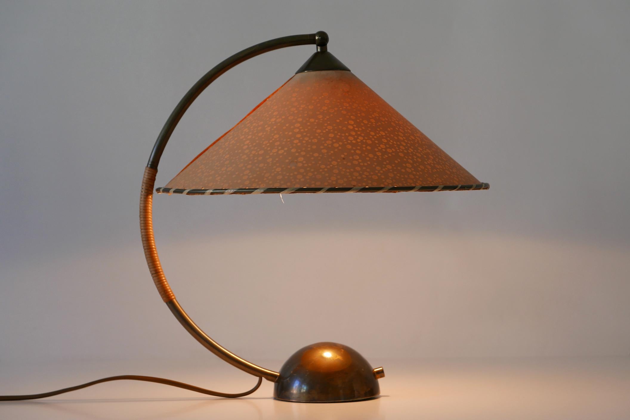 Extremely rare and large Mid-Century Modern table lamp. Designed and manufactured by Pitt Müller, Vilich bei Bonn, 1950s, Germany.

Executed in patinated brass and parchment paper, the lamp comes with 1 x E27 / E26 Edison screw fit bulb holder, is