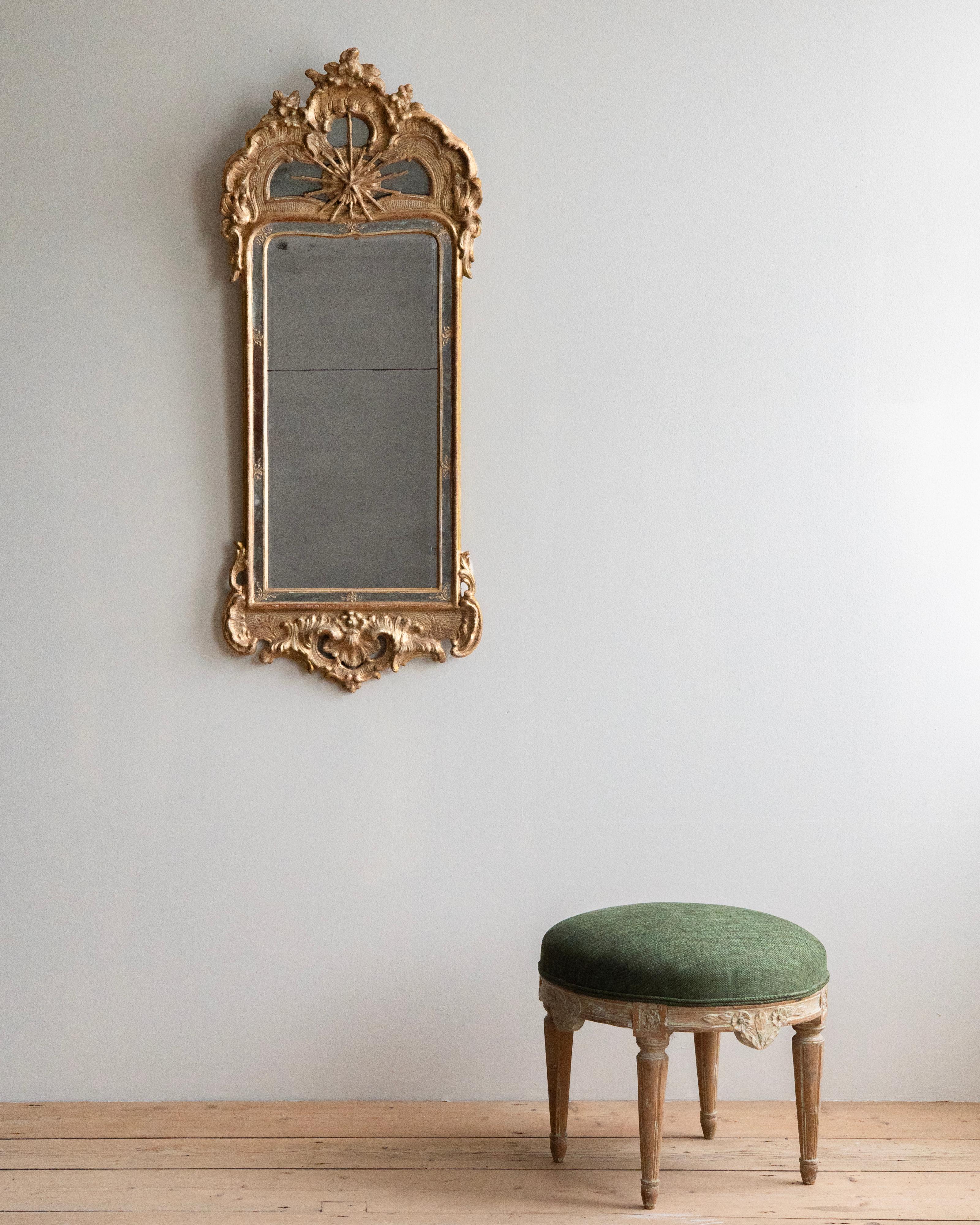 Miroir suédois rococo en bois doré du XVIIIe siècle avec cadre de miroir et étoile polaire. Dans sa finition et son verre miroir d'origine avec une bonne patine. Ca 1760 Stockholm, Suède.

Exemple très rare en raison de la qualité de l'exécution, de