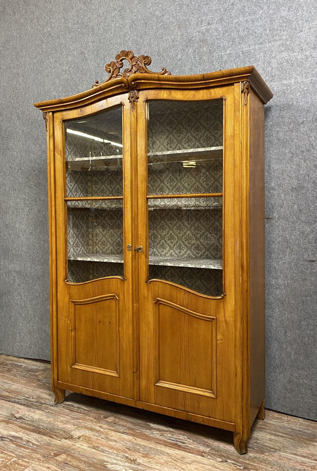 Immerse yourself in the elegance of the 18th century with this exceptional and rare Louis XV light wood bookcase, crafted around 1800. Its exquisite design features a facade adorned with paneled and glazed doors, offering a glimpse into its