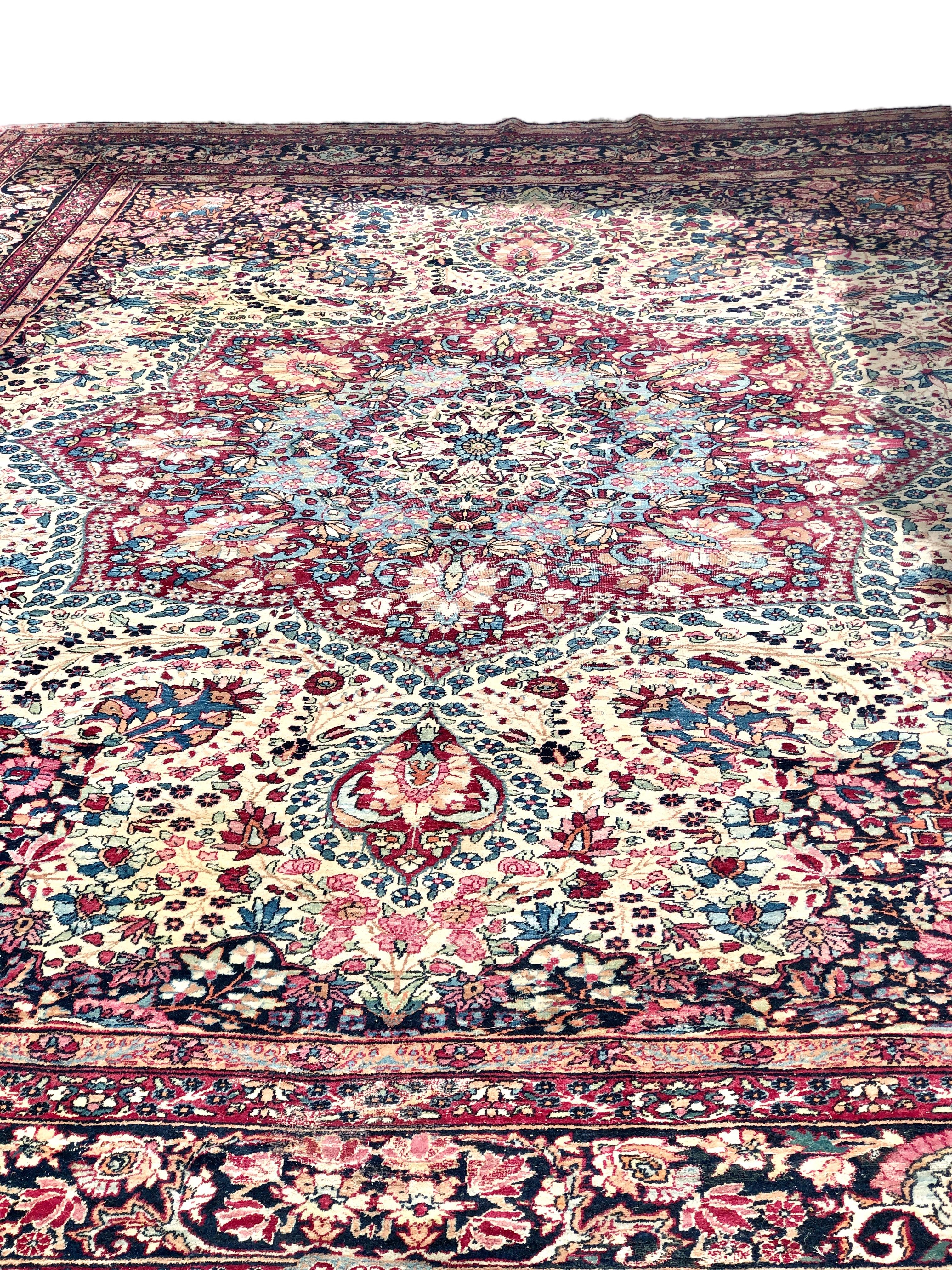 Ein hervorragender antiker persischer Kirman-Teppich, gewebt mit einem faszinierenden Muster, das an ein Buntglasfenster erinnert. Kräftige Rosa-, Blau-, Rot- und Goldtöne finden sich in einem verschlungenen botanischen Design wieder, das sich von