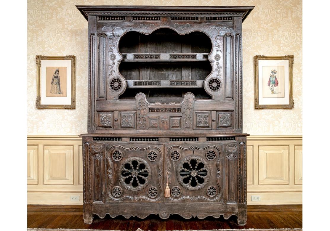 A incredible and massive 19th C. Cupboard from Brittany, France in stained Oak with outstanding European Folk Art carving of Foliate Scroll designs as well as Celtic Crosses, Hearts, Stars and many turned elements as well as the date 1805 centrally