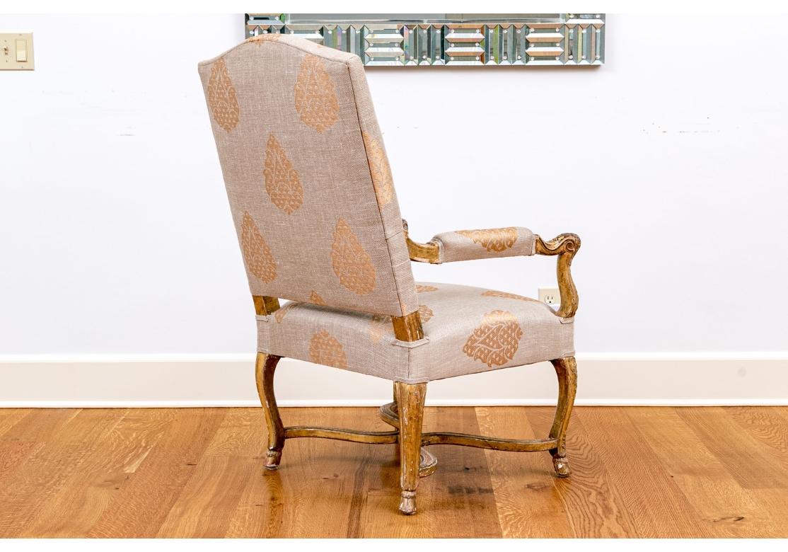 Sillón muy fino con detalles finamente tallados en brazos, patas y bastidor. La silla presenta una pátina envejecida muy fina en el armazón, antaño dorado, con zonas de pérdida de acabado que revelan el gesso subyacente, aunque gran parte del