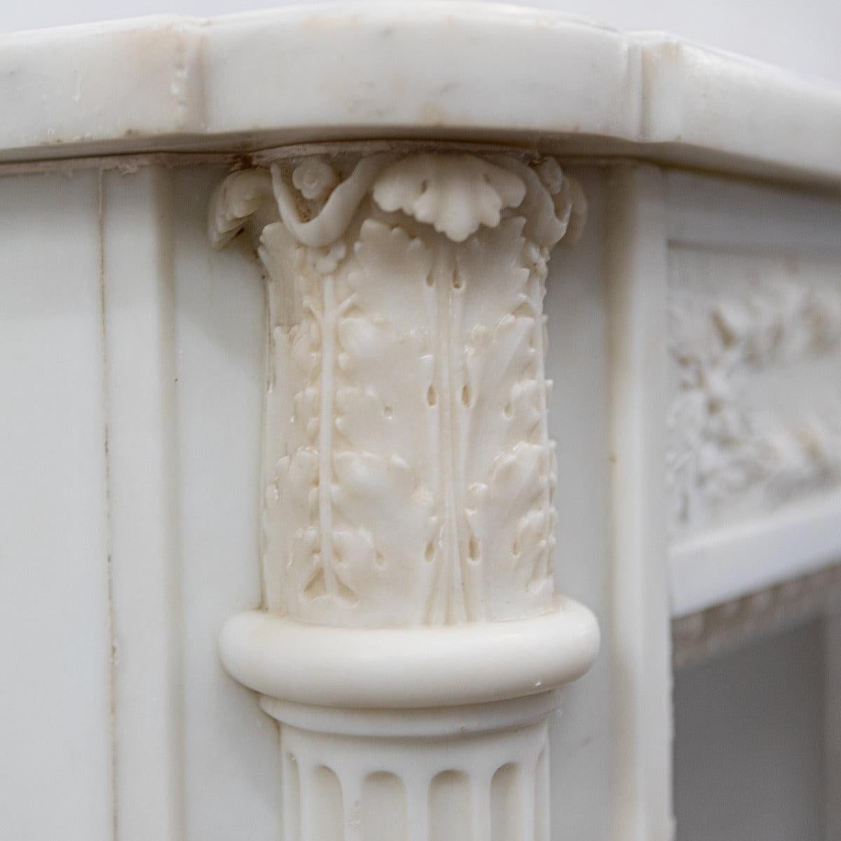 This impressive antique 19th Century, French style Louis XVI fireplace surround has been expertly carved and crafted from fine Statuary marble.

This elegant fireplace has a carved frieze of interlocking leaves, berries and ribbons. The jambs offer
