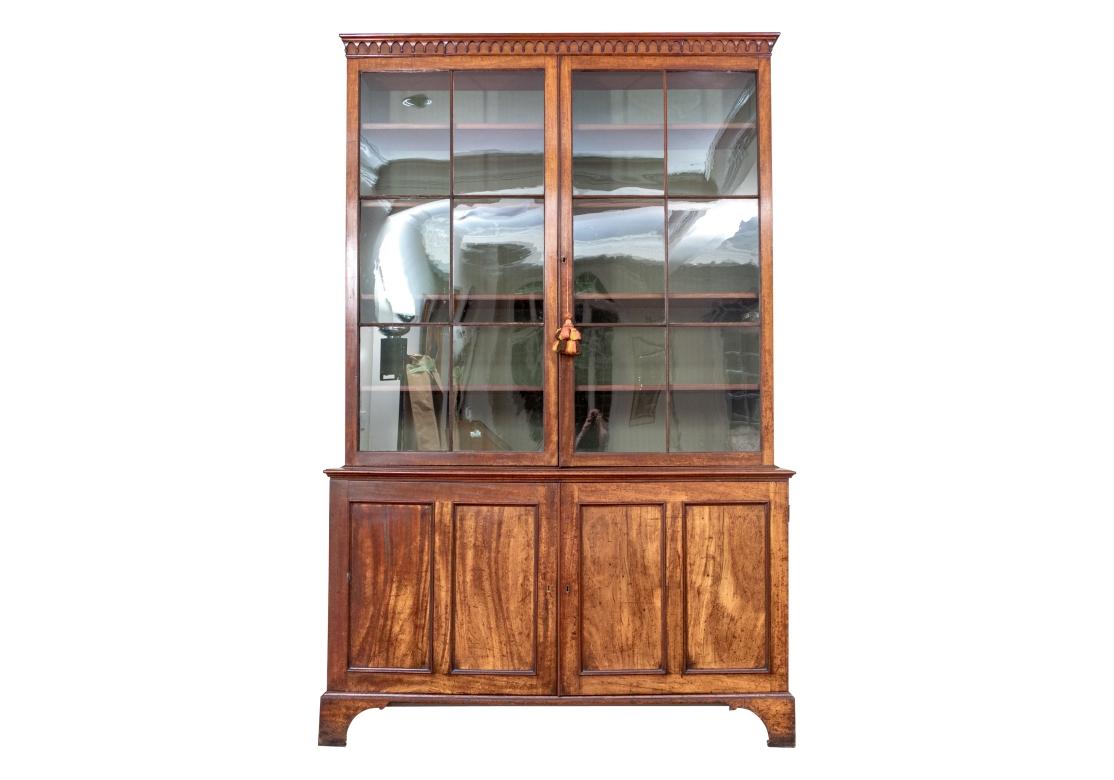 Une vitrine bibliothèque exceptionnelle et très bien faite, avec une exécution particulièrement soignée. Le corps inférieur comporte deux portes à charnières avec des écussons en laiton qui s'ouvrent pour révéler huit tiroirs de rangement. . Le