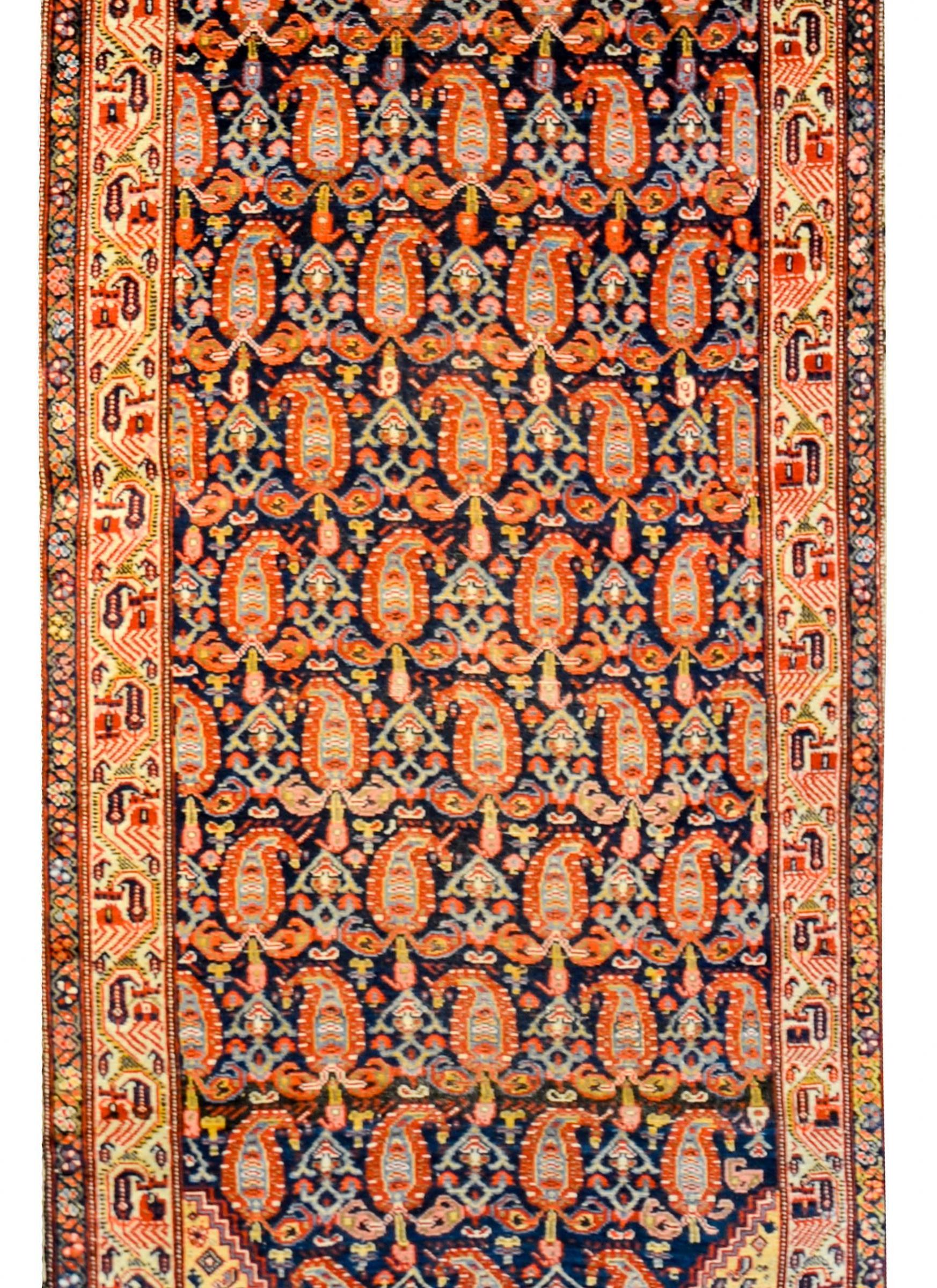 Exceptional early 20th century antique Persian Malayer runner with an all-over multicolored paisley pattern on a dark indigo background. The border is wonderful with a complementary paisley pattern on a white background, and a thin petite stylized