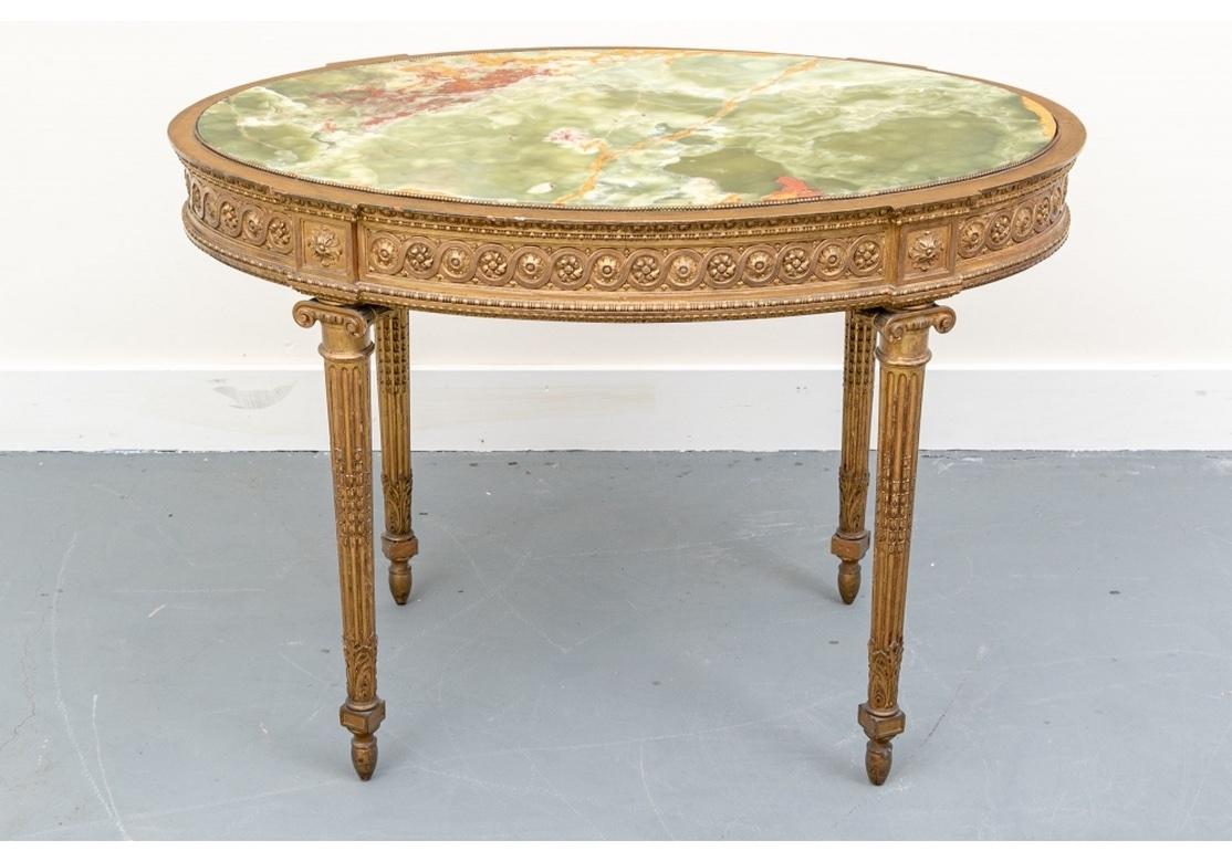 An elaborate and colorful Antique Oval Center Table. A beautifully crafted oval table with an inset green onyx top with brass beaded surround. The carved and gilt apron with running circles with rosette centers, an egg-and-dart upper edge and