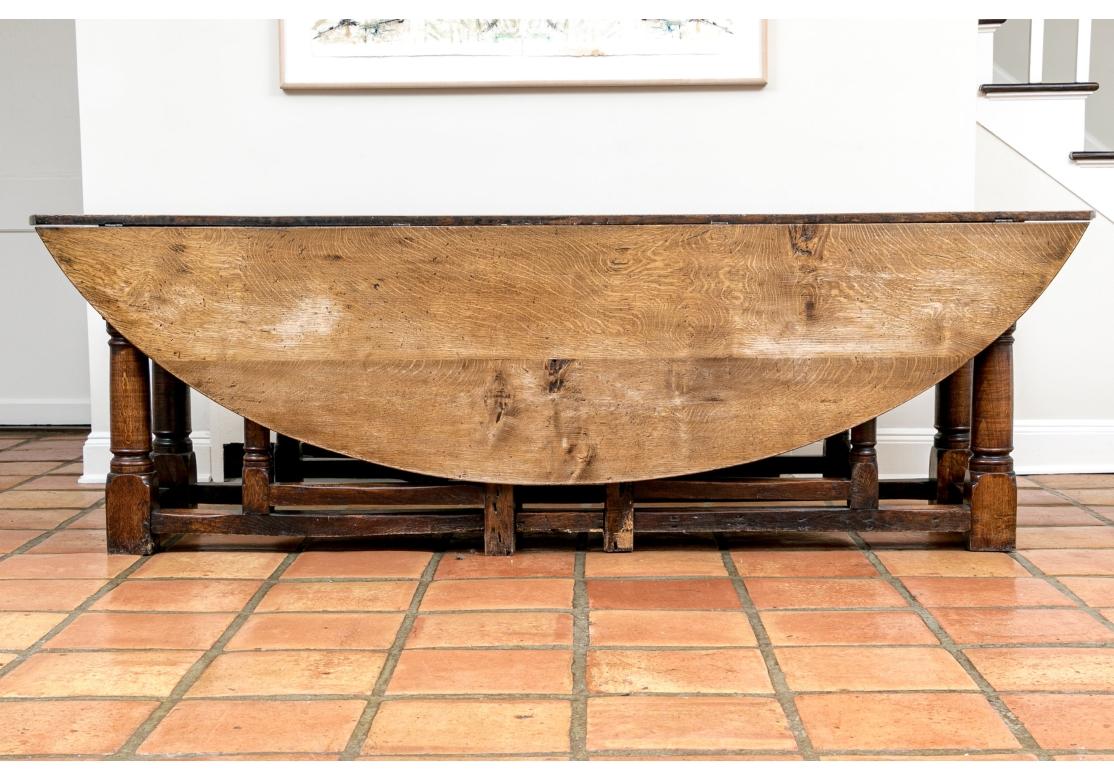 Belle table à abattant du 19e siècle, de grande taille, en beau bois, de bon poids et de forme traditionnelle admirable. Le plateau de la table, qui a subi une usure due à l'âge, repose sur une base à pieds en forme de grille composée de supports de