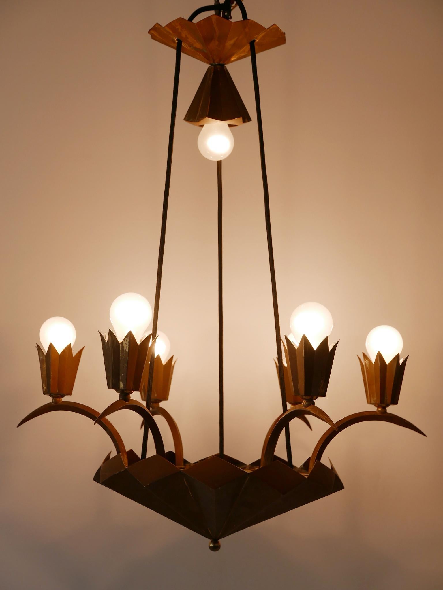 Extremely rare and decorative Cubist Art Deco brass chandelier or pendant lamp. Designed and manufactured probably in Austria or Czech Republic, 1920s.

Executed in brass, the lamp comes with 7 x E27 / E26 Edison screw fit bulb holders, is rewired